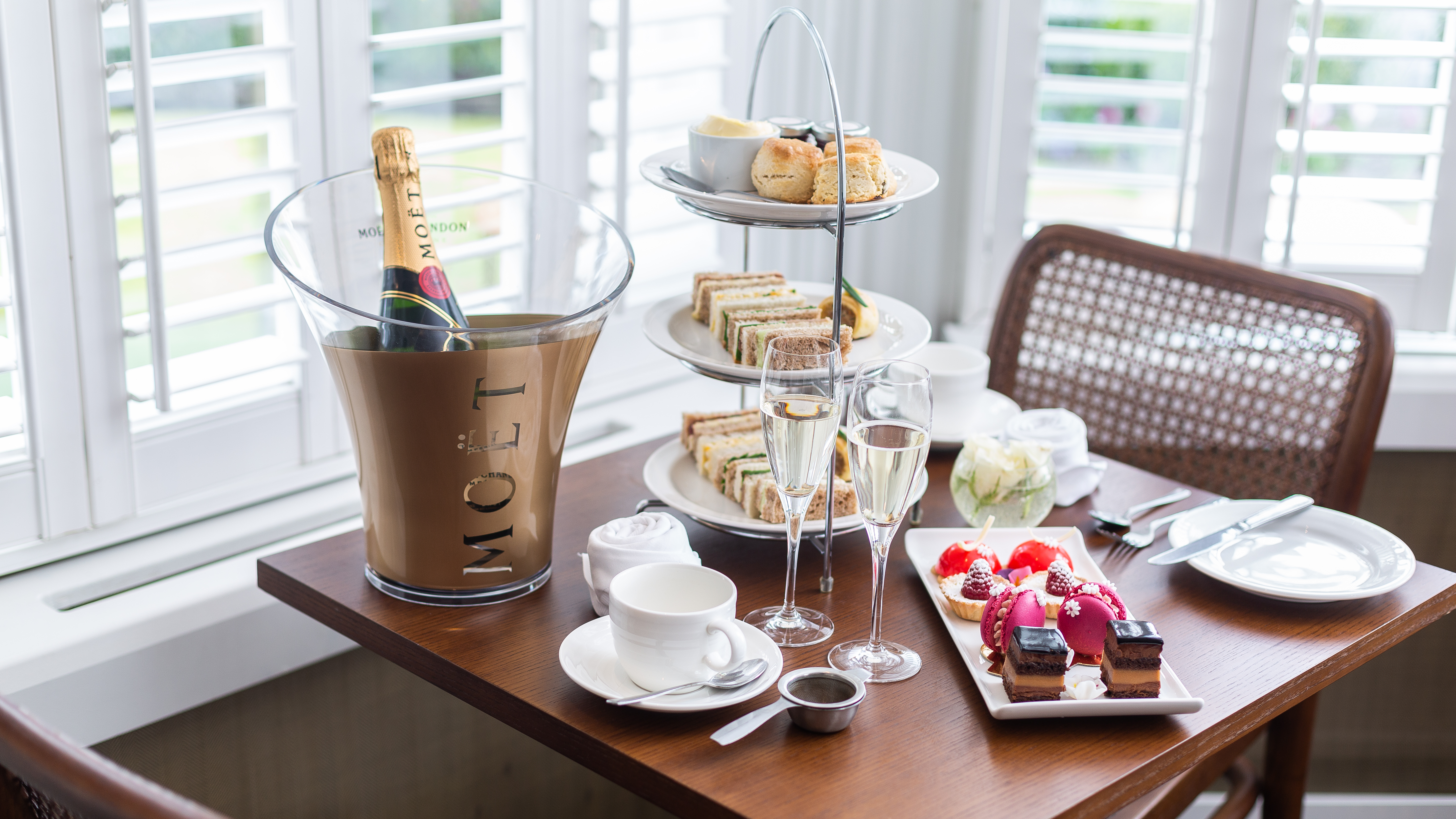 Elegant afternoon tea setup at Henrietta Bar & Garden, featuring fine china and pastries.