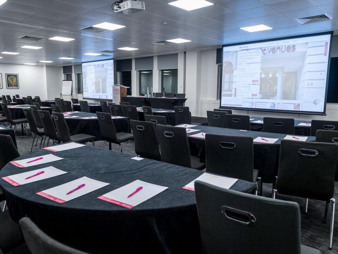 Exclusive Hire meeting room with round tables, ideal for professional events and conferences.
