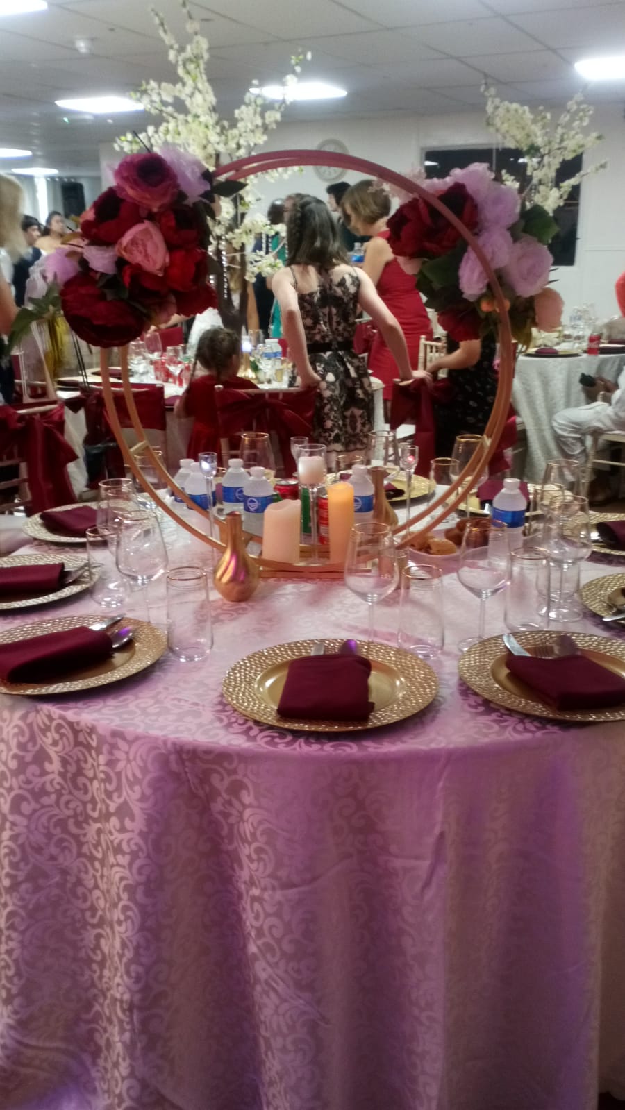 Elegant dining table with burgundy napkins for weddings or corporate events.
