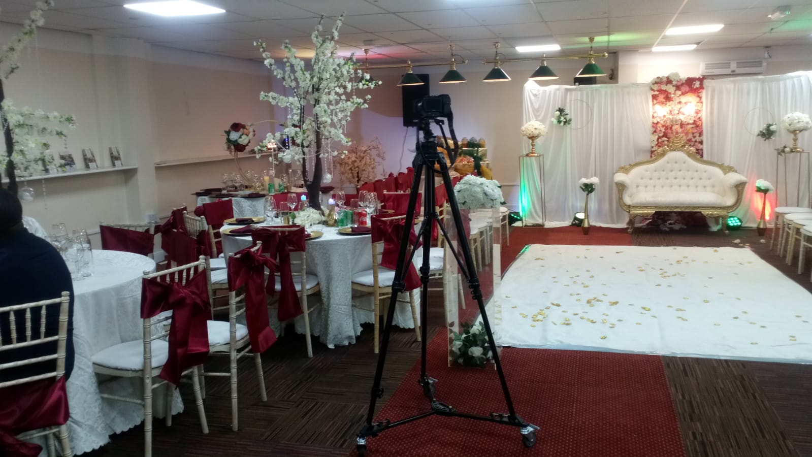 Elegant wedding event space with floral backdrop and red sashes at P2 Centre.