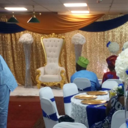 Elegant event space with throne chair, floral decor for weddings and celebrations.