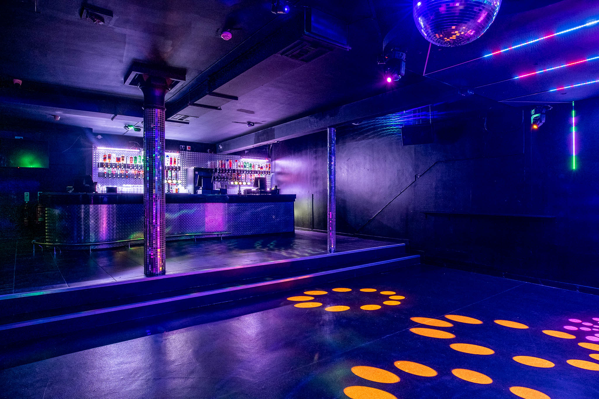 Vibrant Manchester event space with sleek bar and dynamic lighting for lively gatherings.
