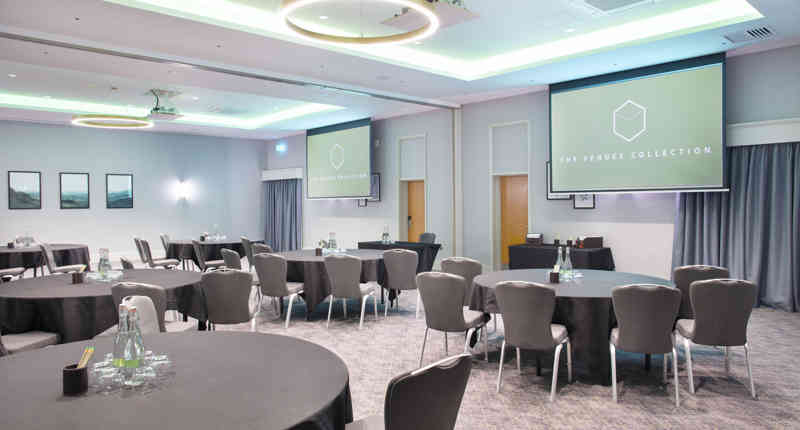 Modern event space at Sedgebrook Hall with round tables for corporate meetings.