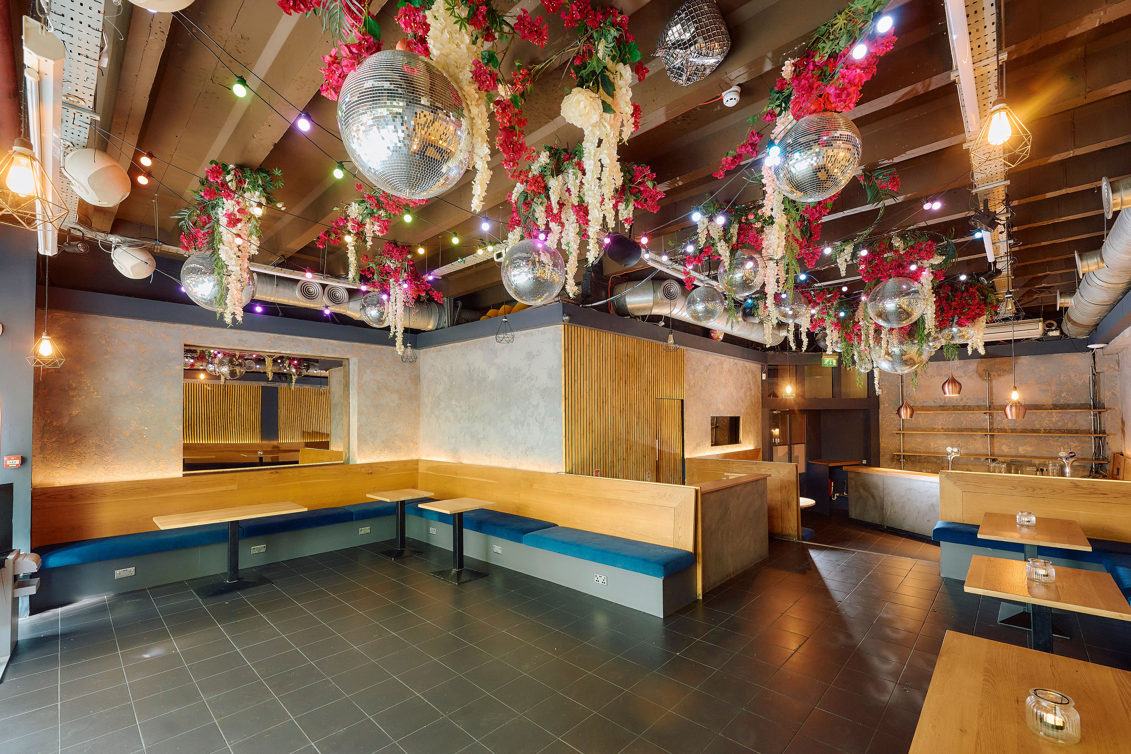 Vibrant event space with floral decor and disco balls at Colours Hoxton.