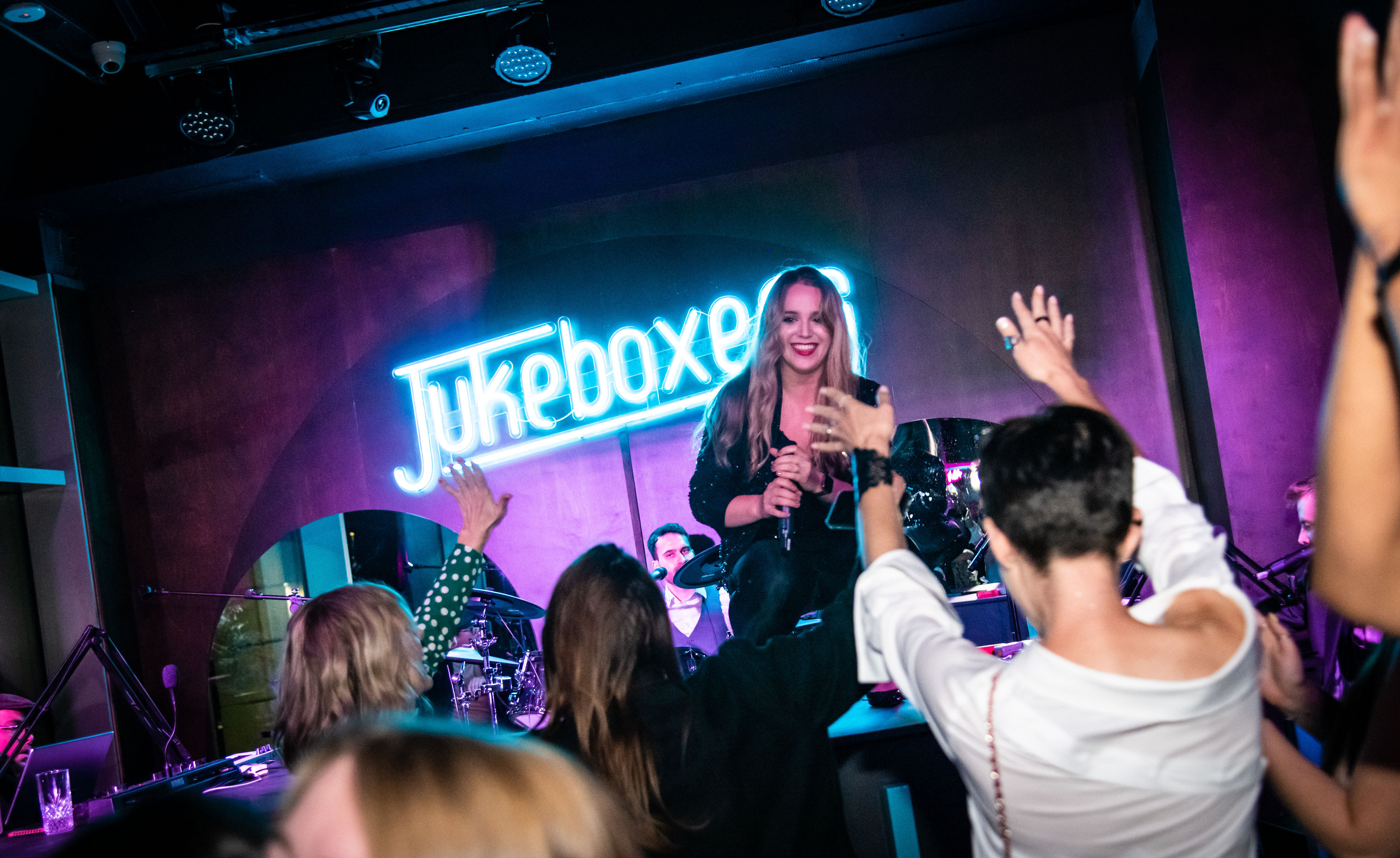 Vibrant event space with engaging performer at Jukeboxers Duelling Piano Bar.