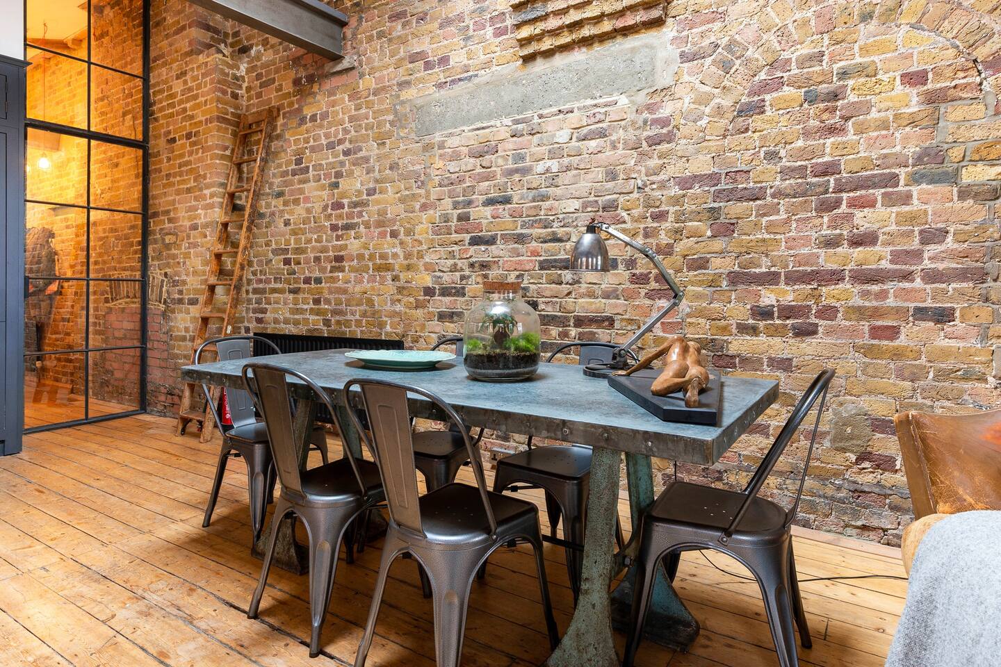 Stylish Shoreditch warehouse loft meeting space with rustic brick wall and modern table.