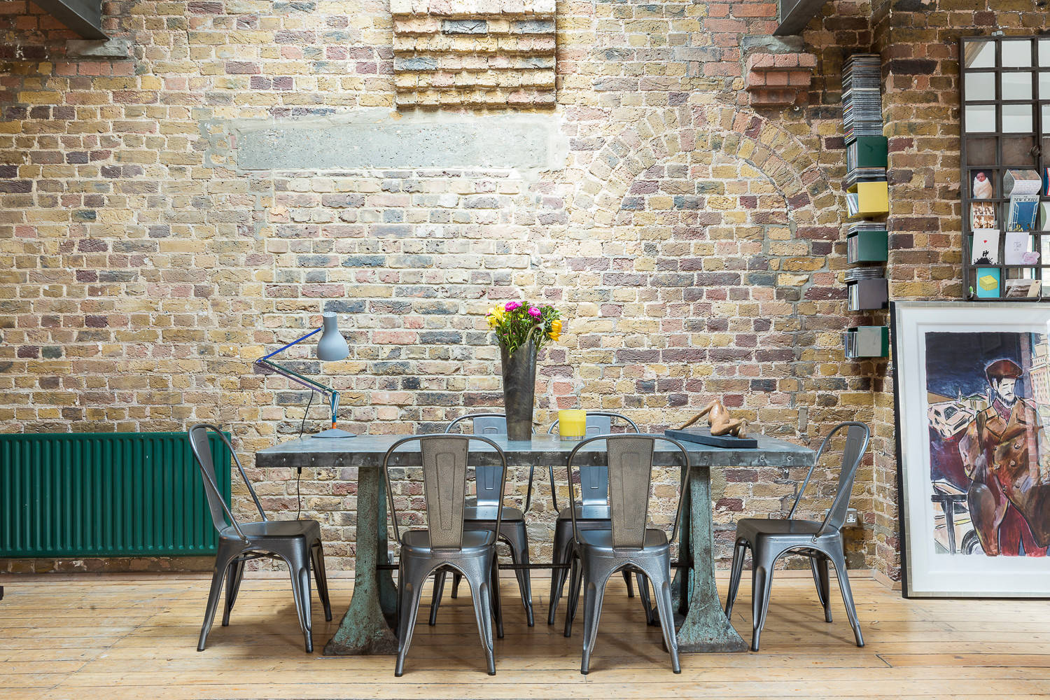 Stylish meeting space in Shoreditch loft with rustic brick wall and large table.