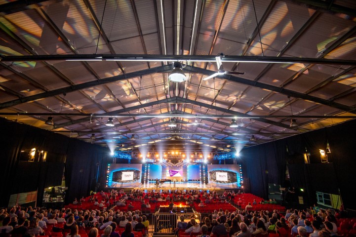 Royal Welsh Showground conference setup with tiered seating and vibrant lighting.