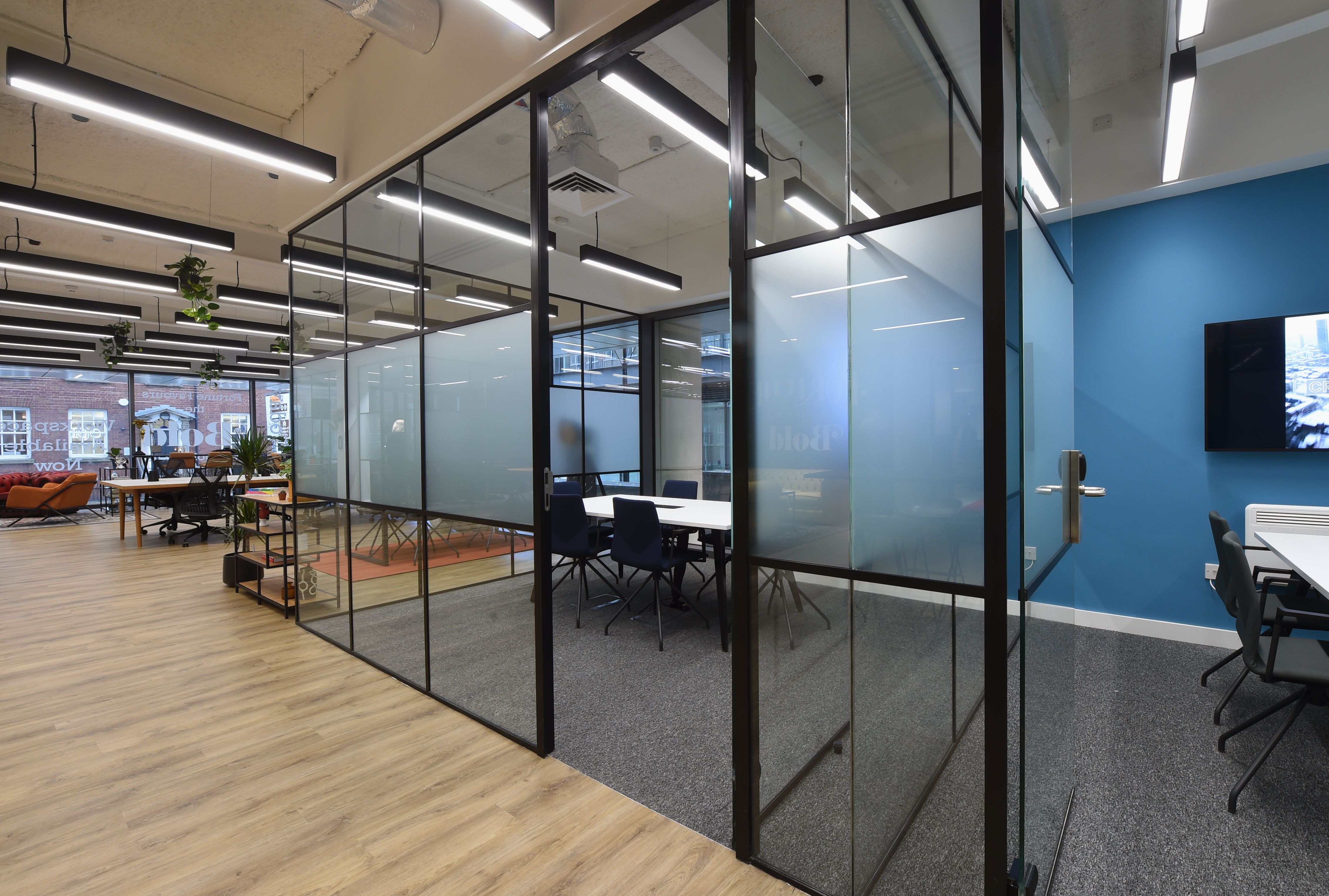 Modern meeting space with glass-walled rooms for collaborative events and brainstorming.