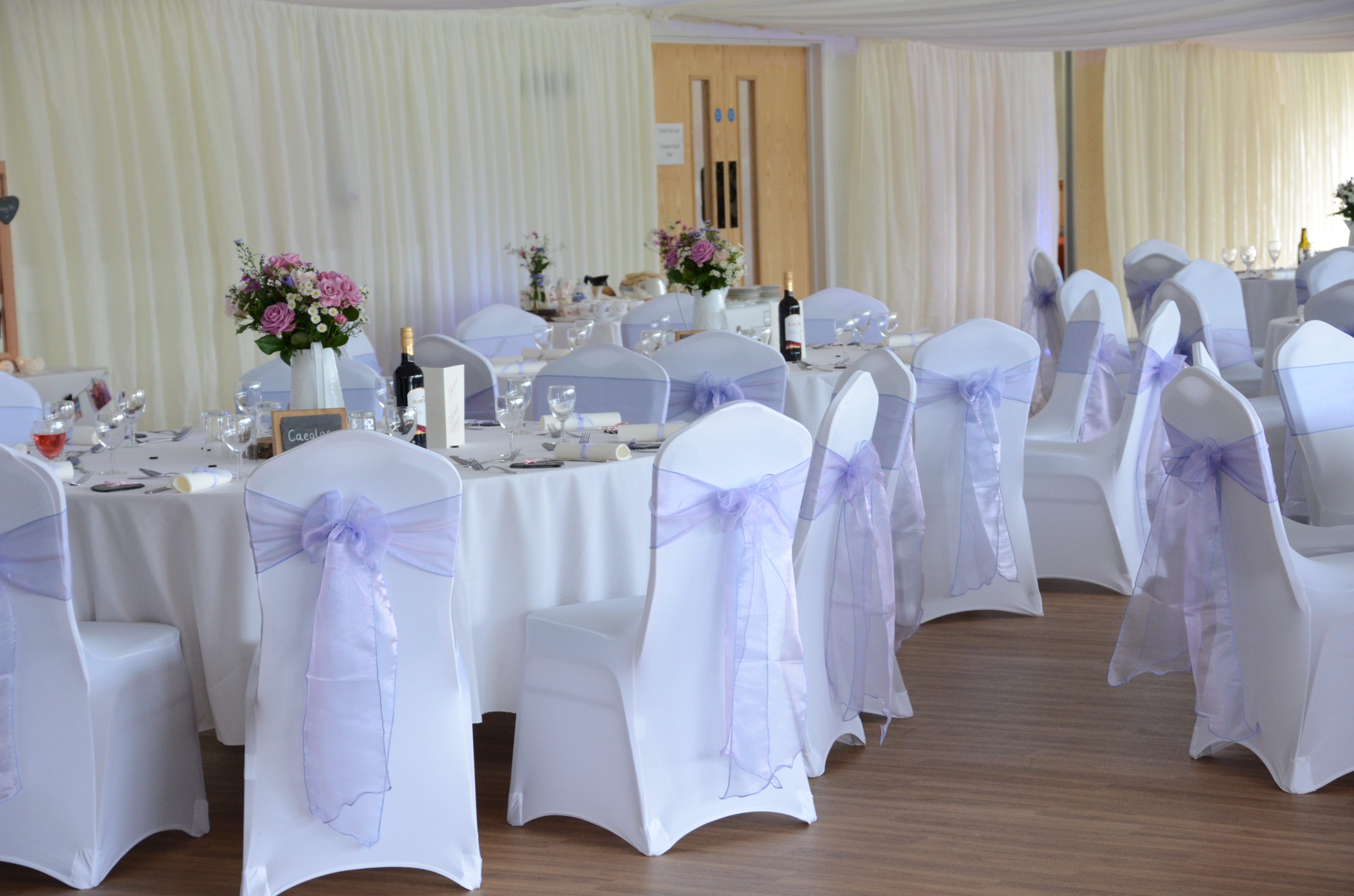 Elegant wedding venue with round tables and floral centerpieces at Royal Welsh Showground.
