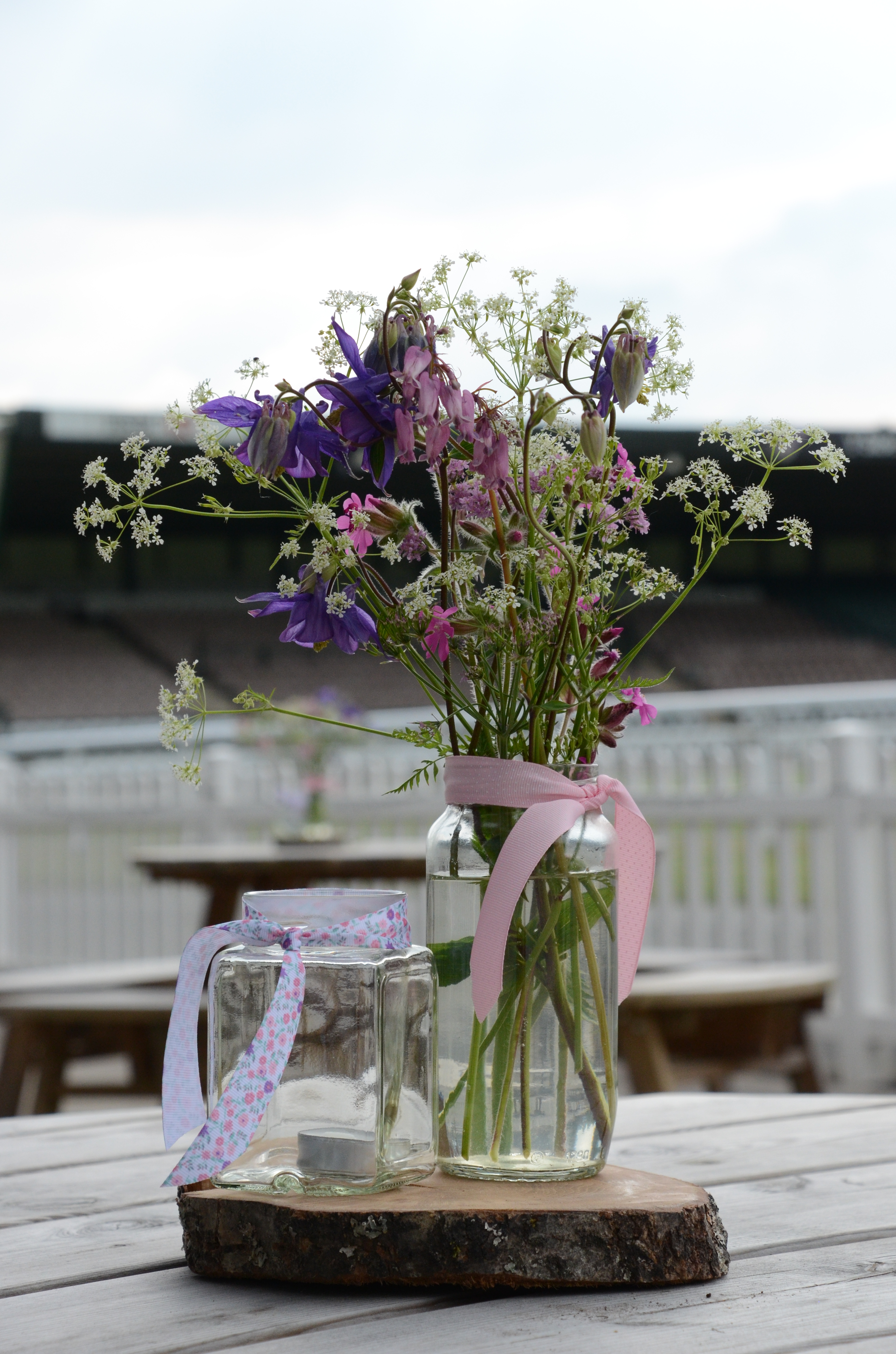Floral centerpiece in glass jars at Royal Welsh Showground for weddings and garden parties.