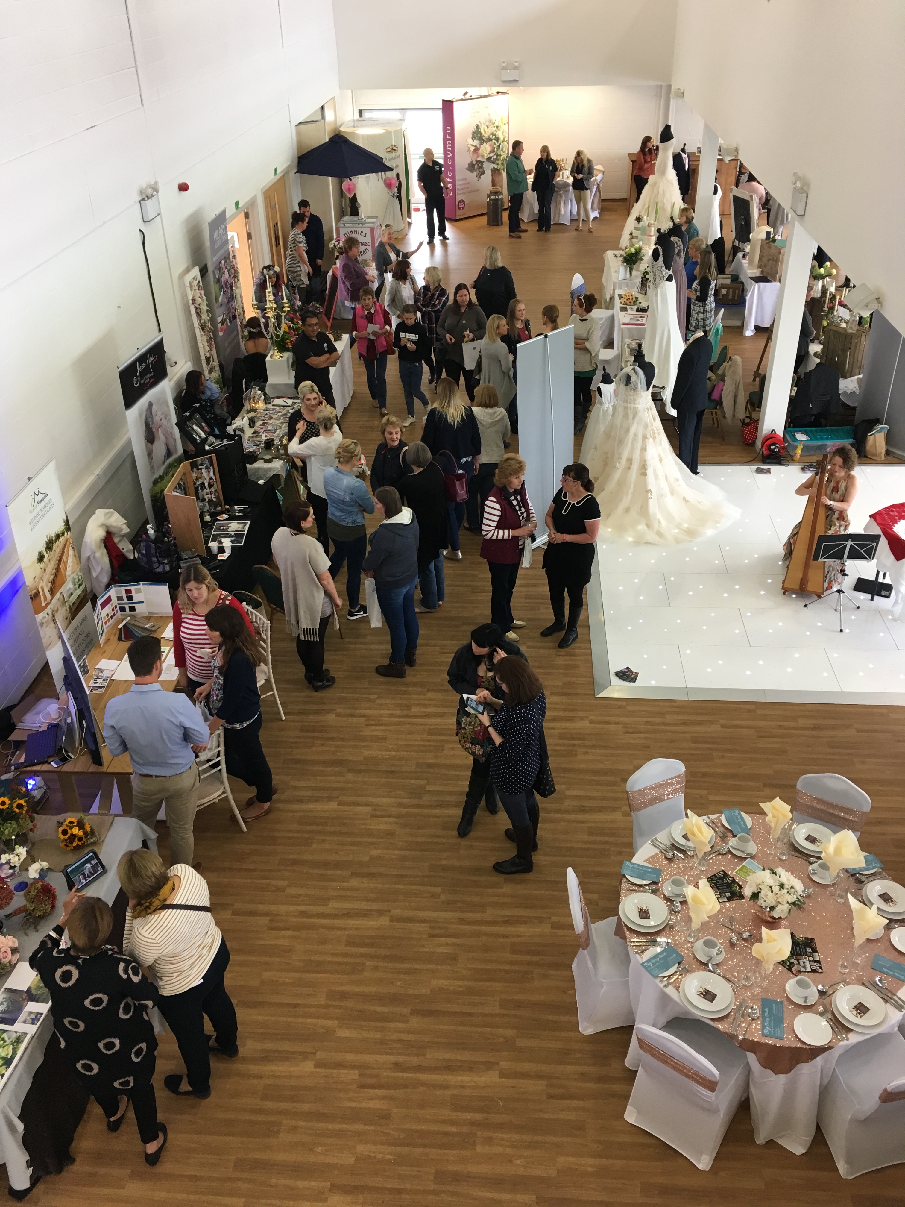 Royal Welsh Showground Members Centre bustling wedding fair with vendor booths and attendees.