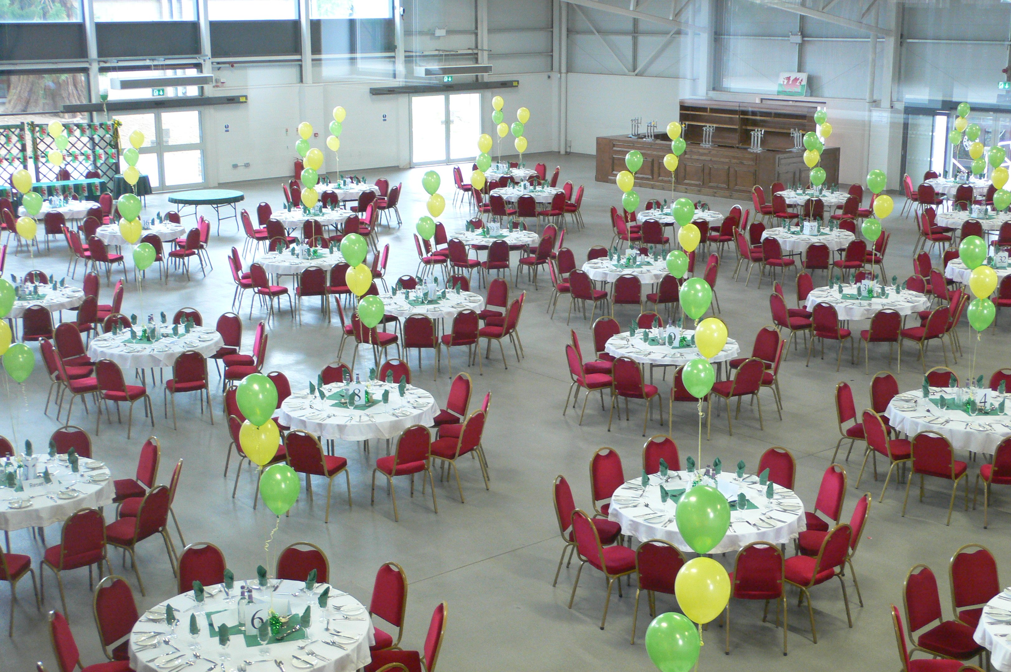 Food Hall at Royal Welsh Showground with round tables, ideal for conferences and celebrations.