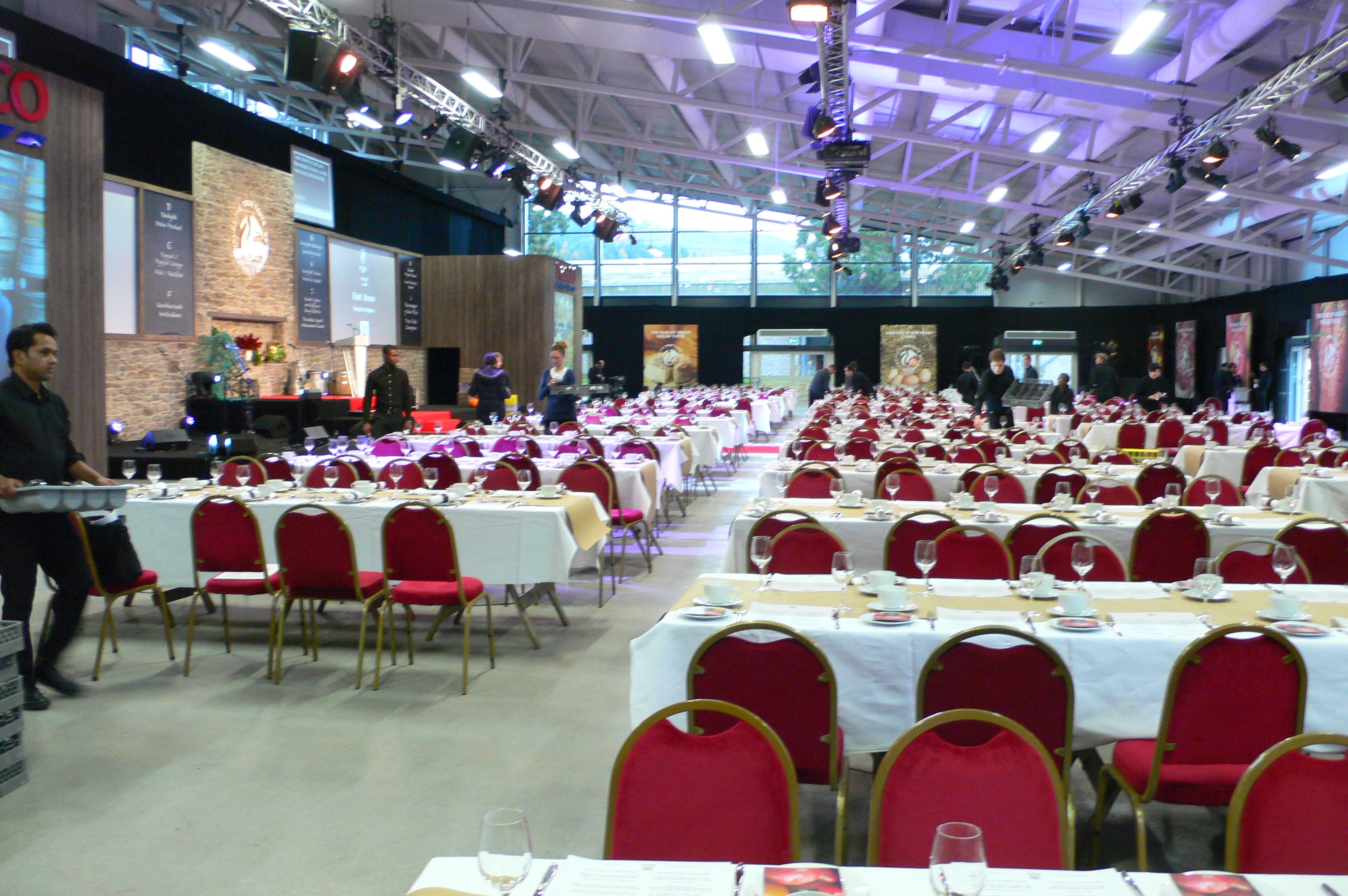 Elegant banquet setup with red chairs at Royal Welsh Showground for corporate events.
