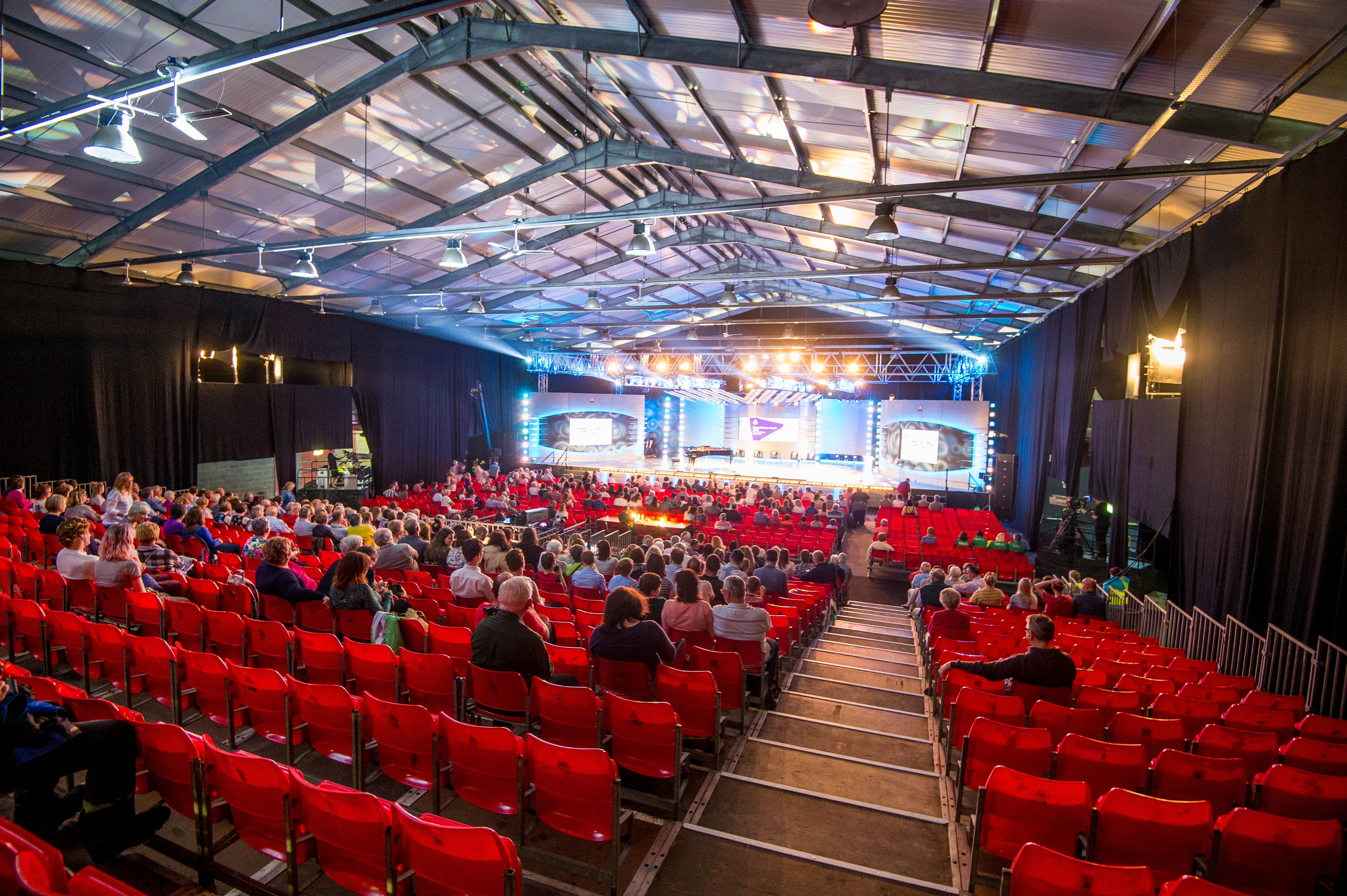 Exhibition Hall at Royal Welsh Showground, red seating for conferences and performances.