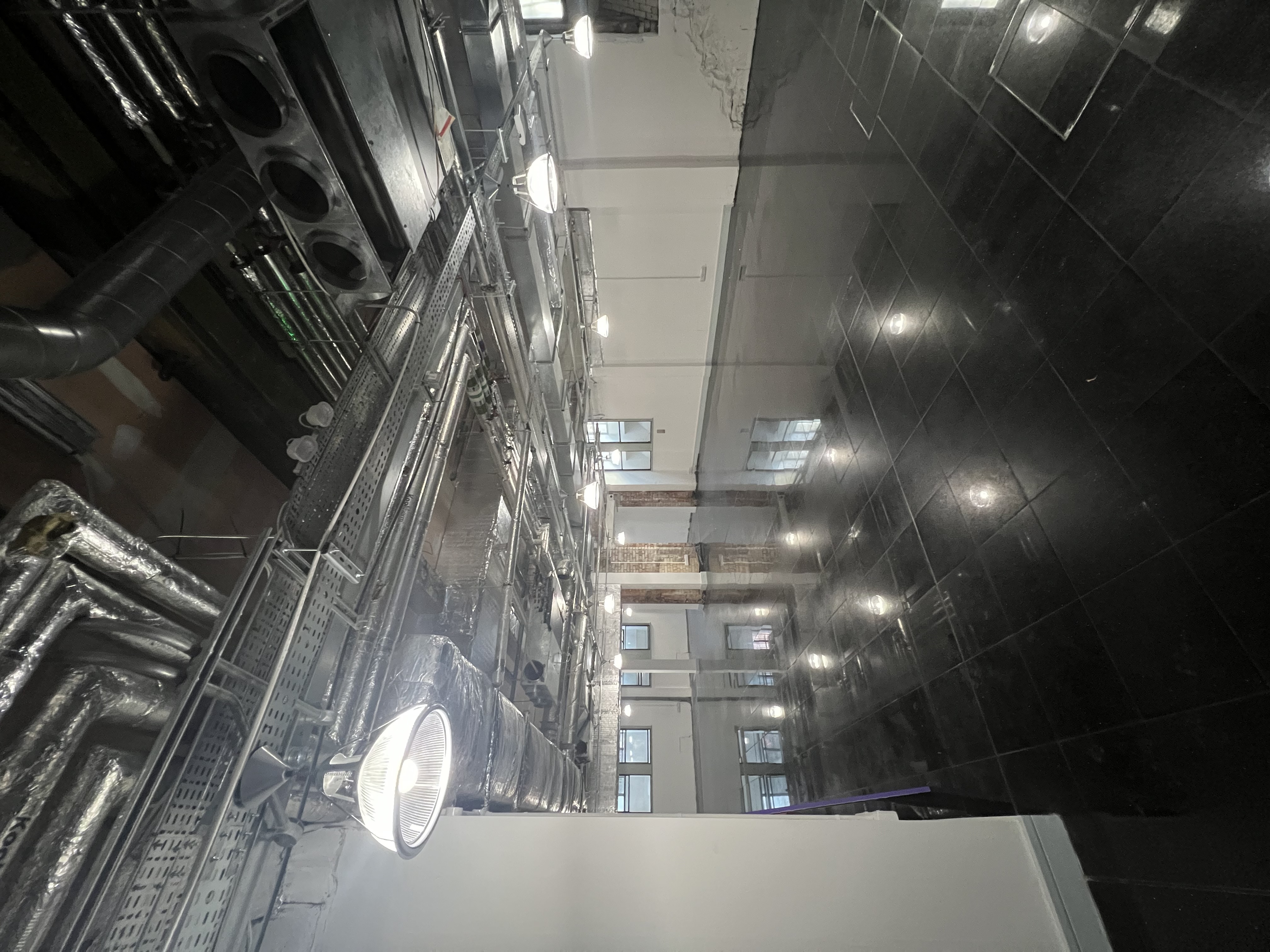 Modern industrial event space with polished floors, ideal for meetings and workshops.