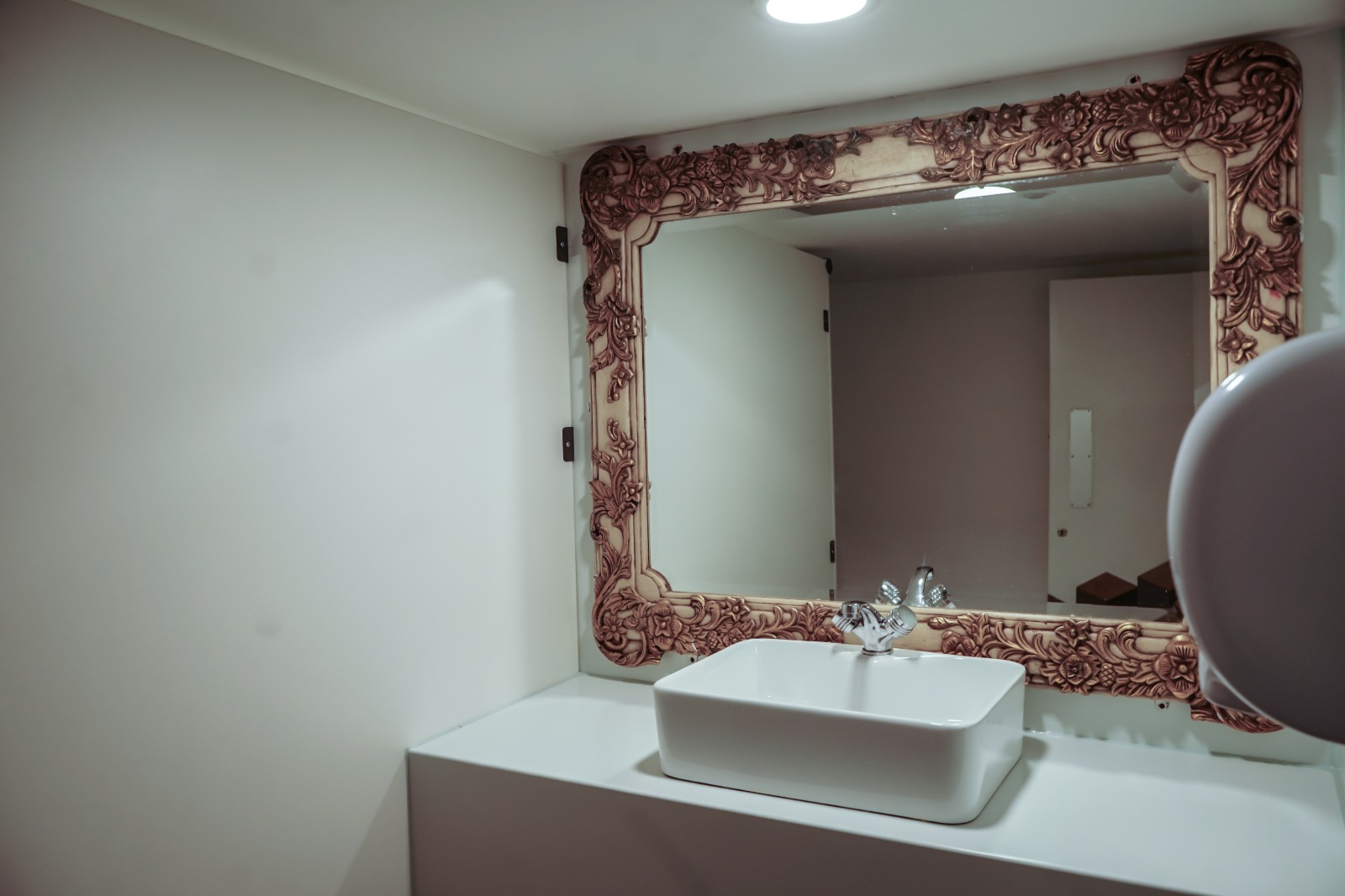 Stylish restroom at Black Box Studio with ornate mirror, ideal for events and meetings.