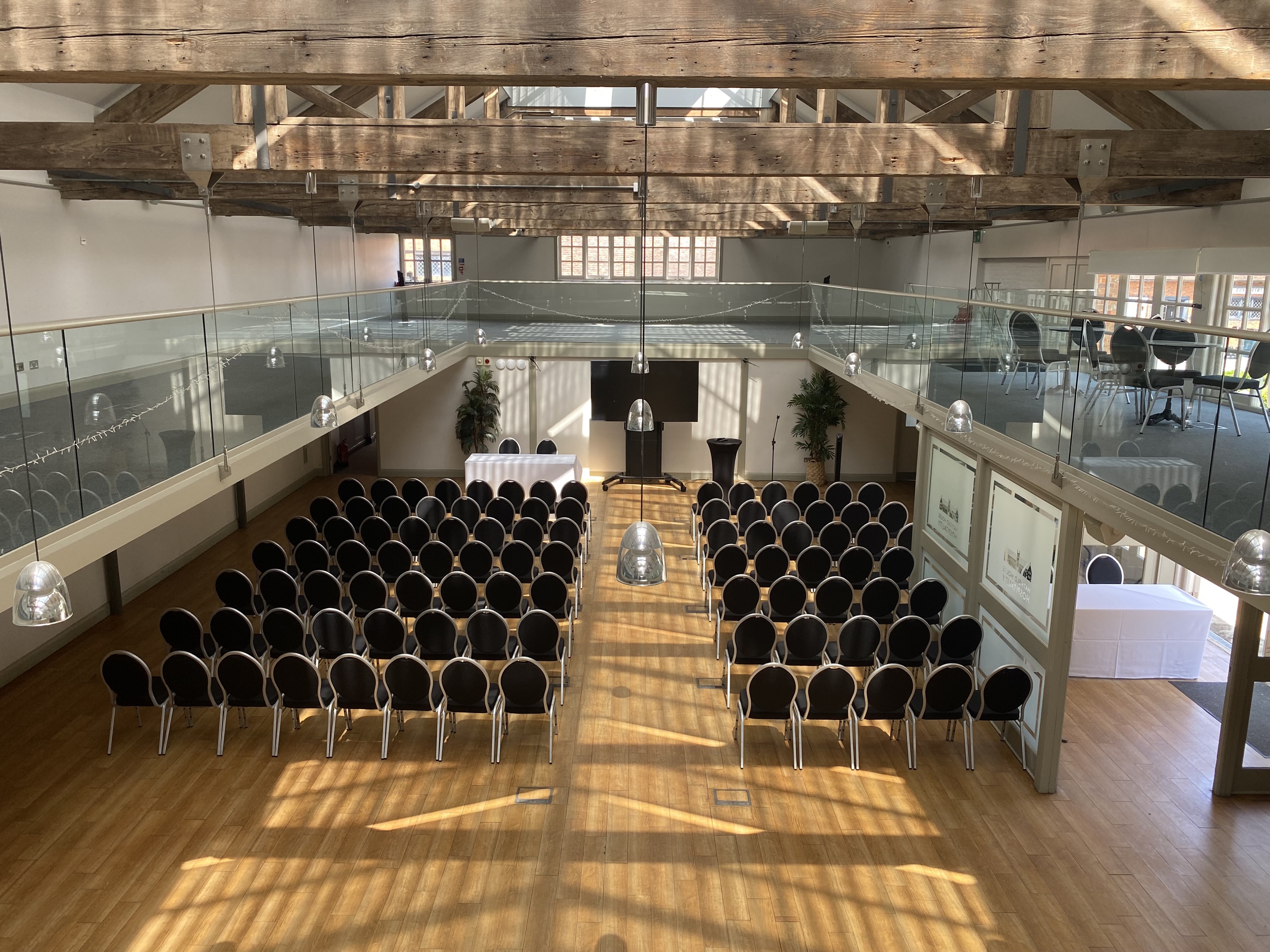 Spacious Riding School venue with black chairs, ideal for conferences and presentations.