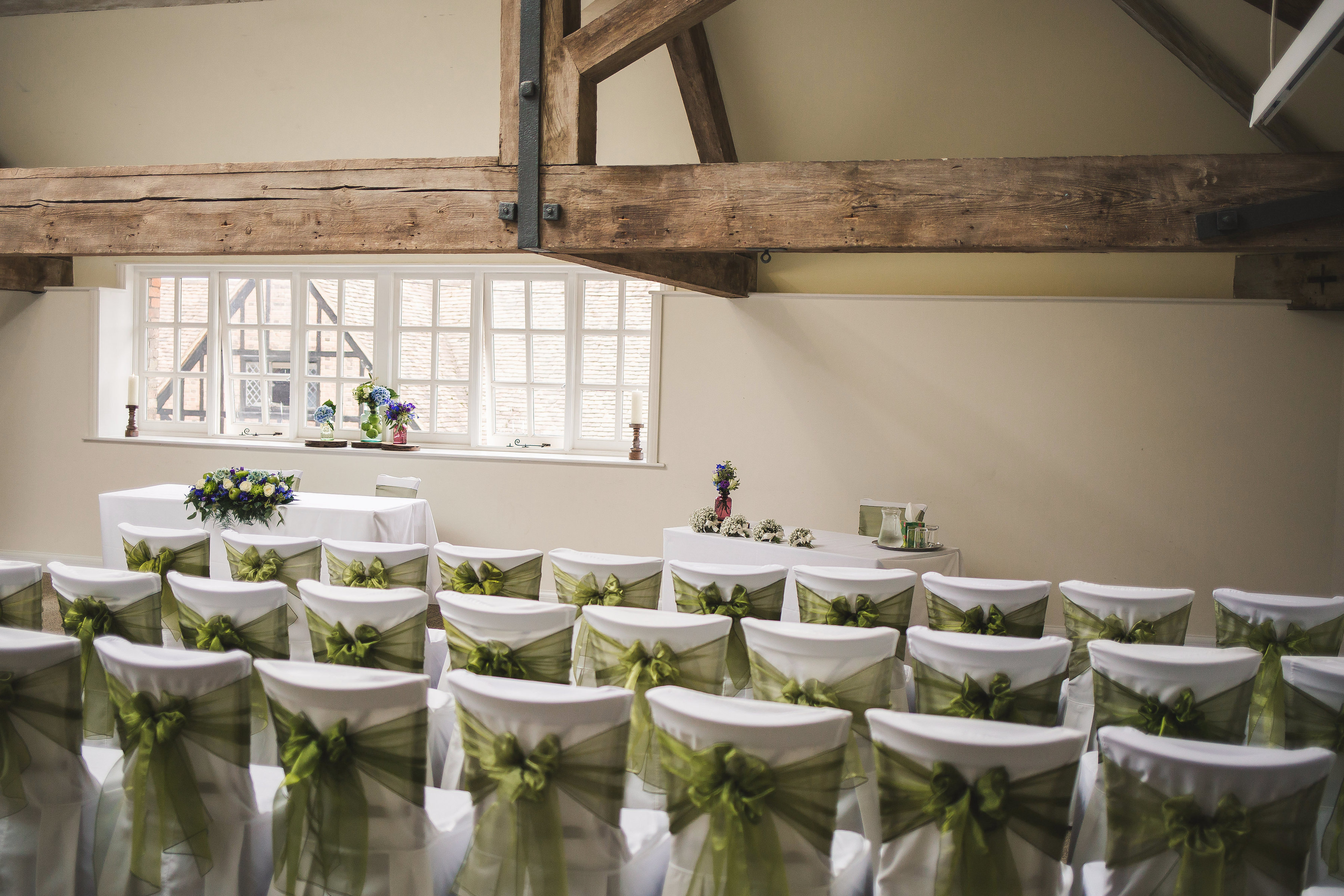 Elegant wedding venue with green-sashed chairs at Hatfield House Riding School.
