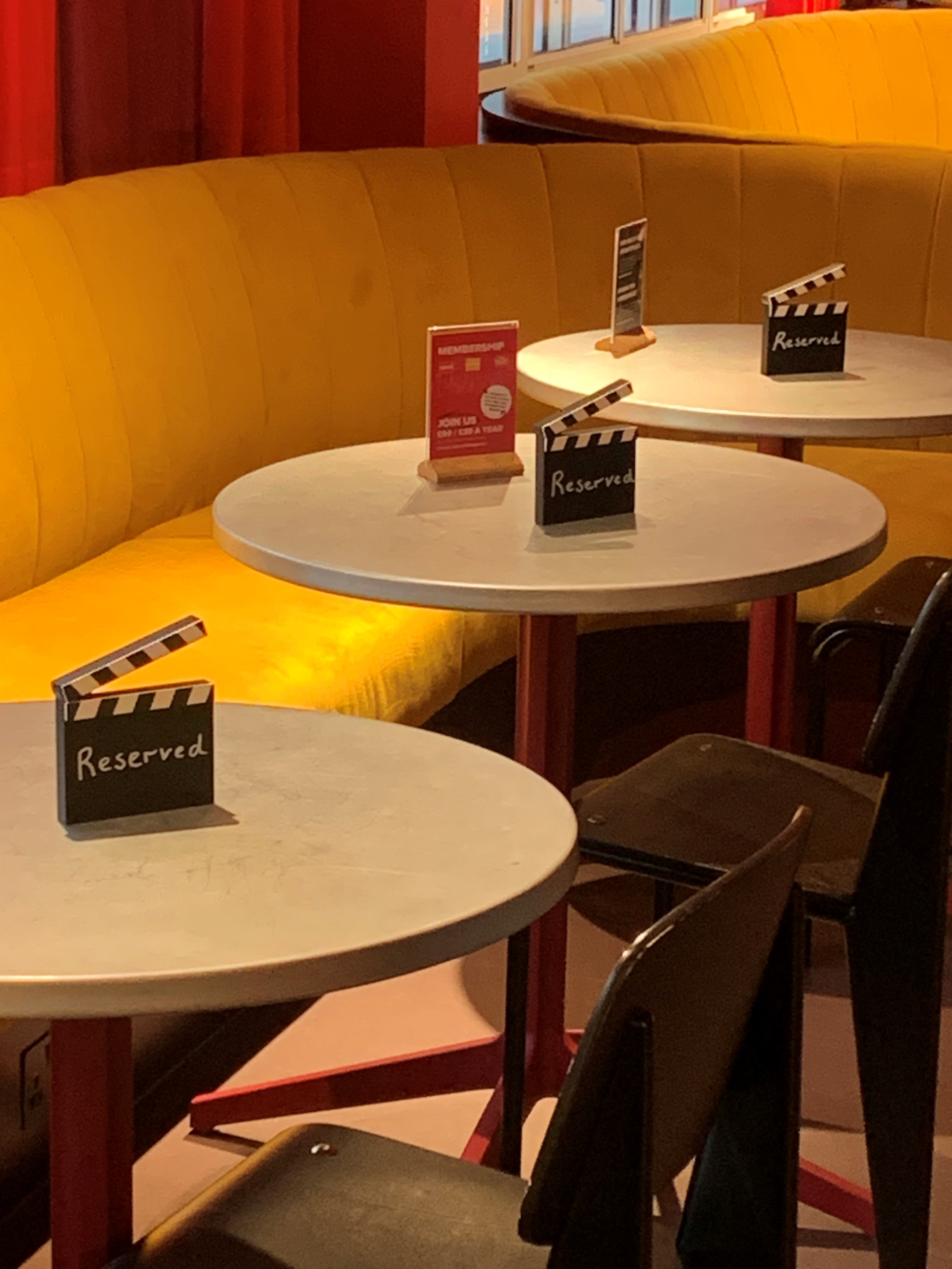 Cozy Cinema Bar event space with vibrant yellow seating for film-themed gatherings.