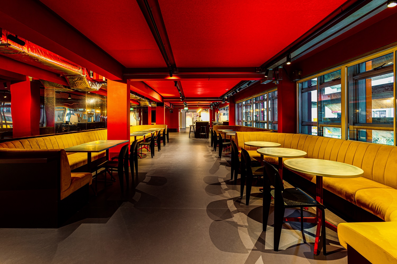 Vibrant Cinema Bar event space with red accents, perfect for networking and meetings.