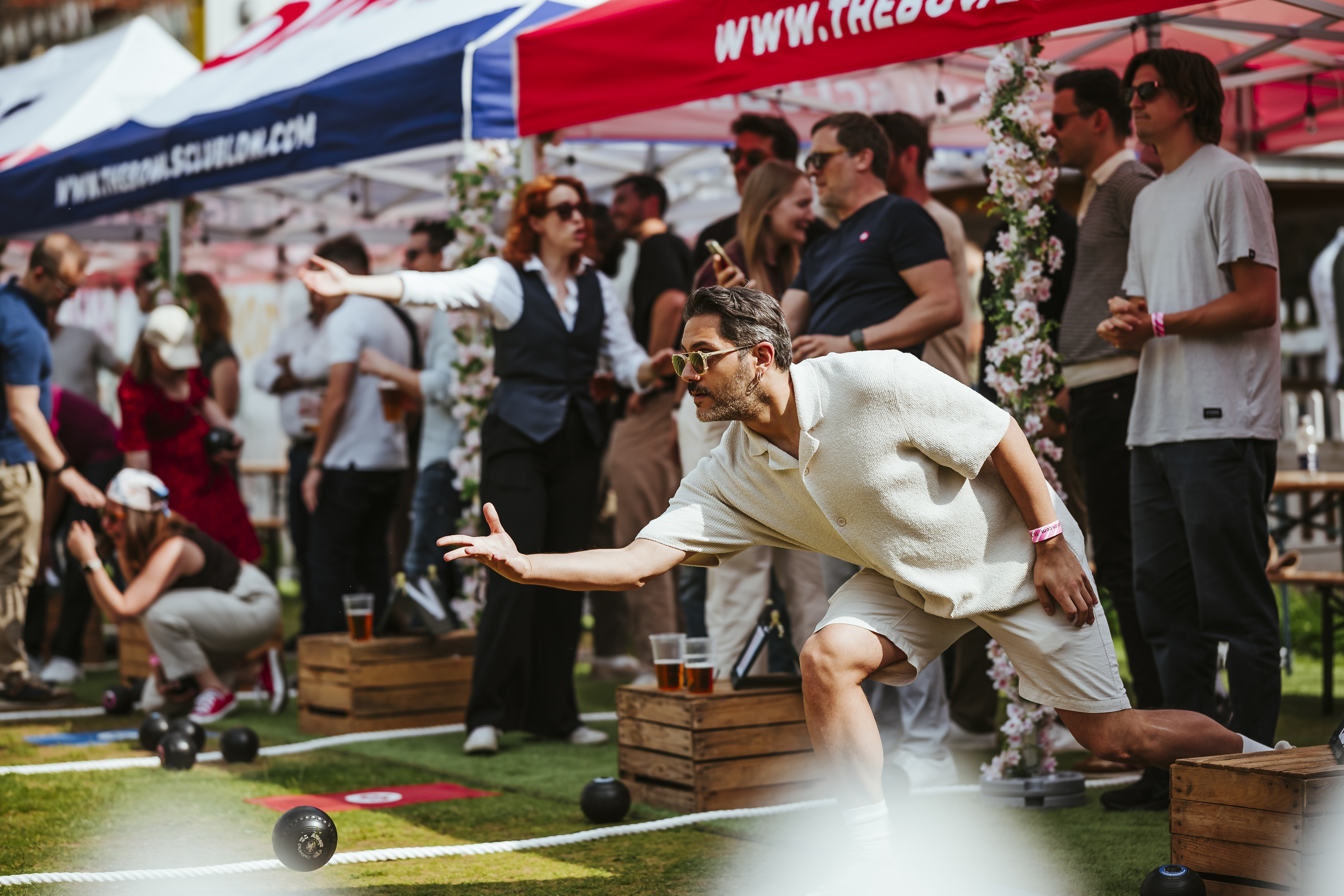 Outdoor team-building event at The Bowls Club, featuring vibrant tents and casual games.