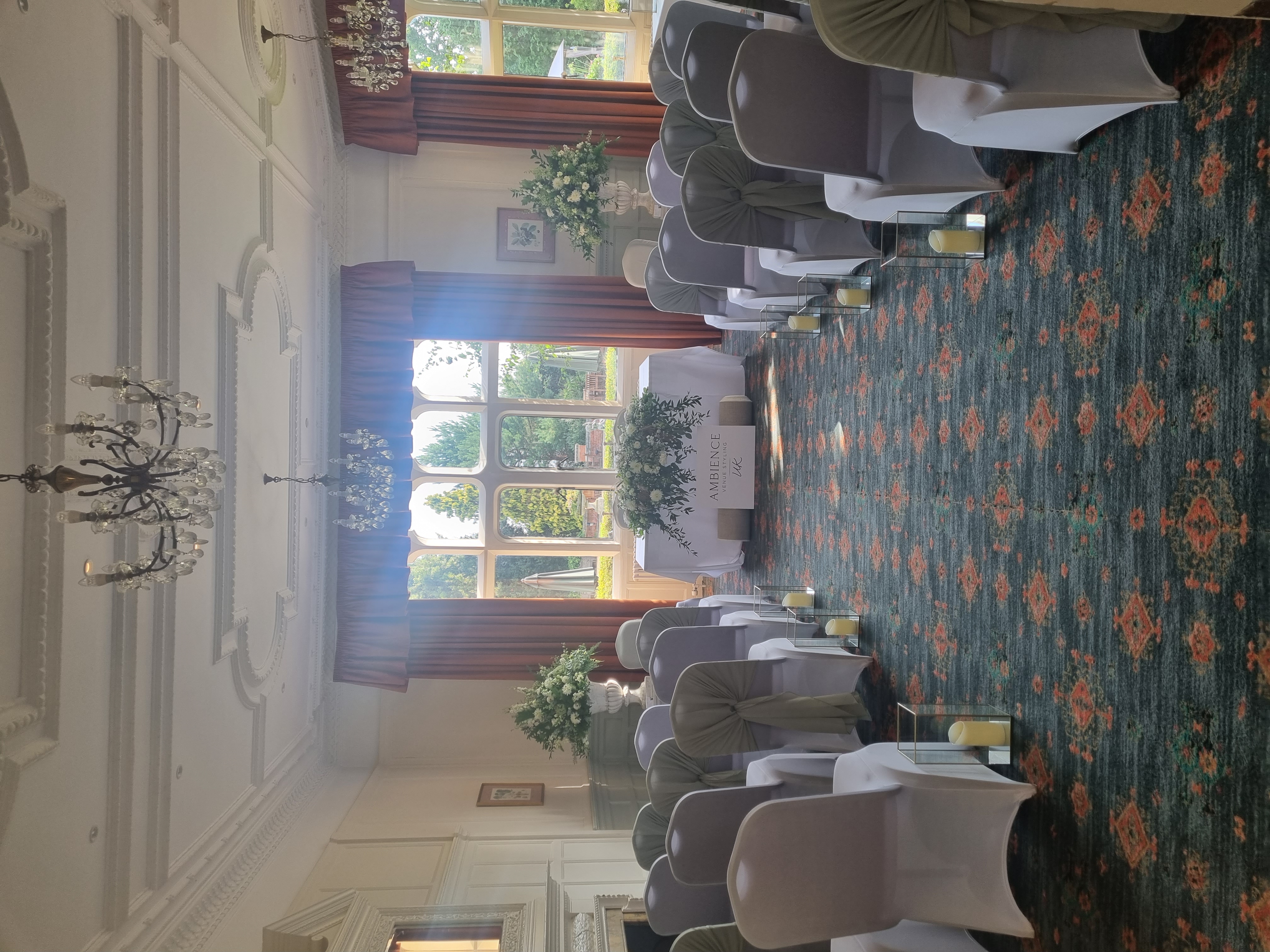 Elegant wedding ceremony setup at Warren House Hotel with floral arrangements and soft green sashes.