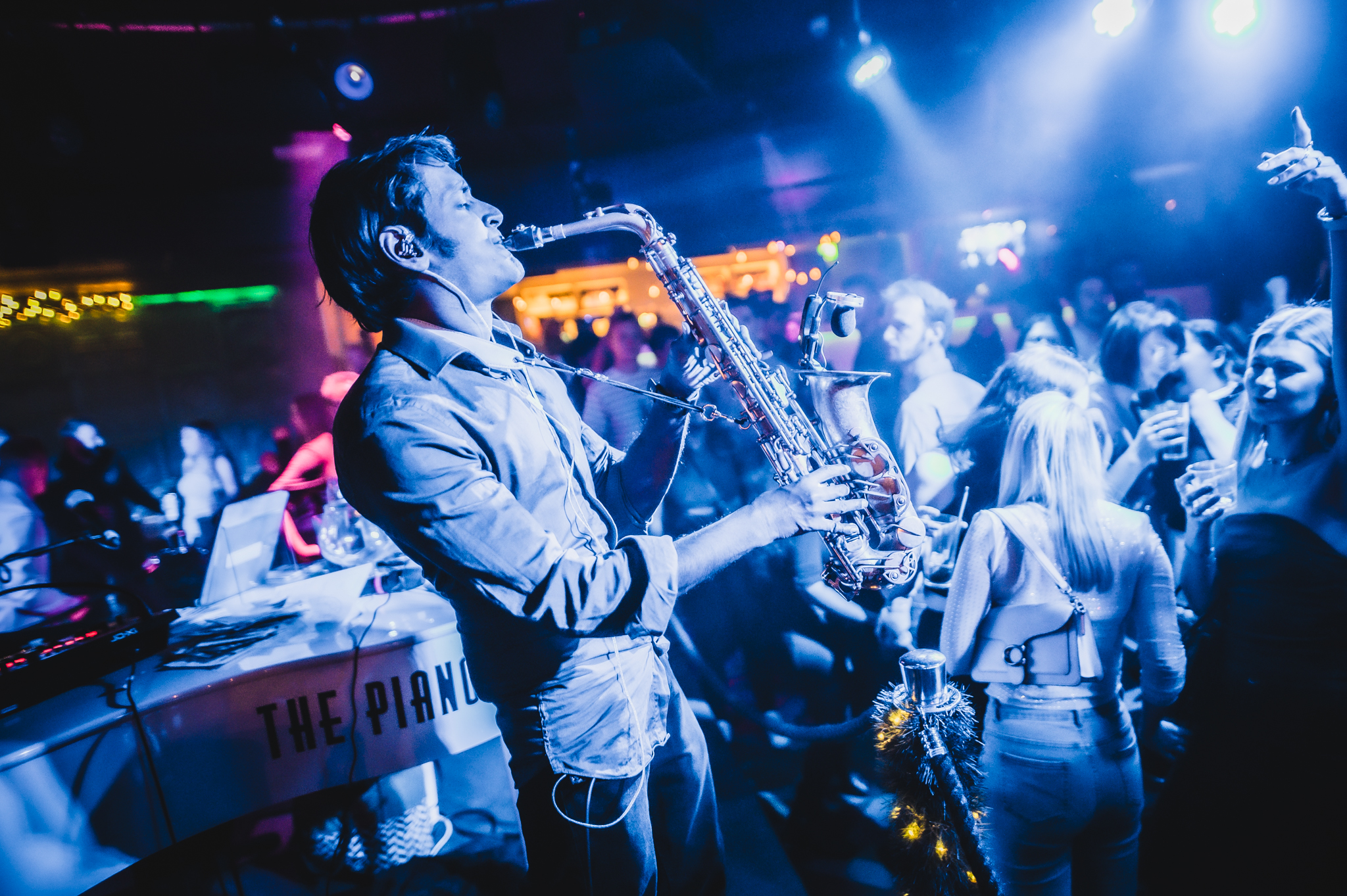 Vibrant event at The Piano Works Farringdon with live saxophonist and dynamic lighting.