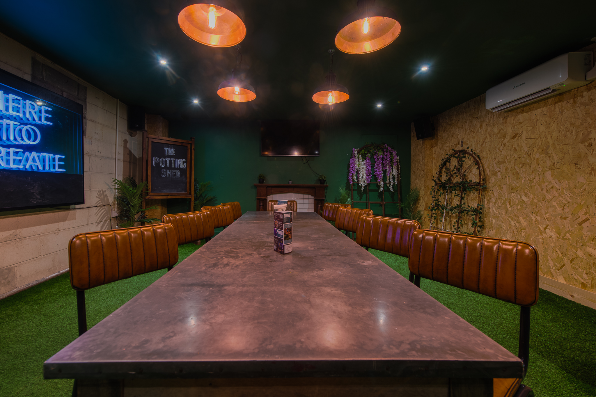 Modern meeting space with industrial table and greenery in Swansea for creative events.