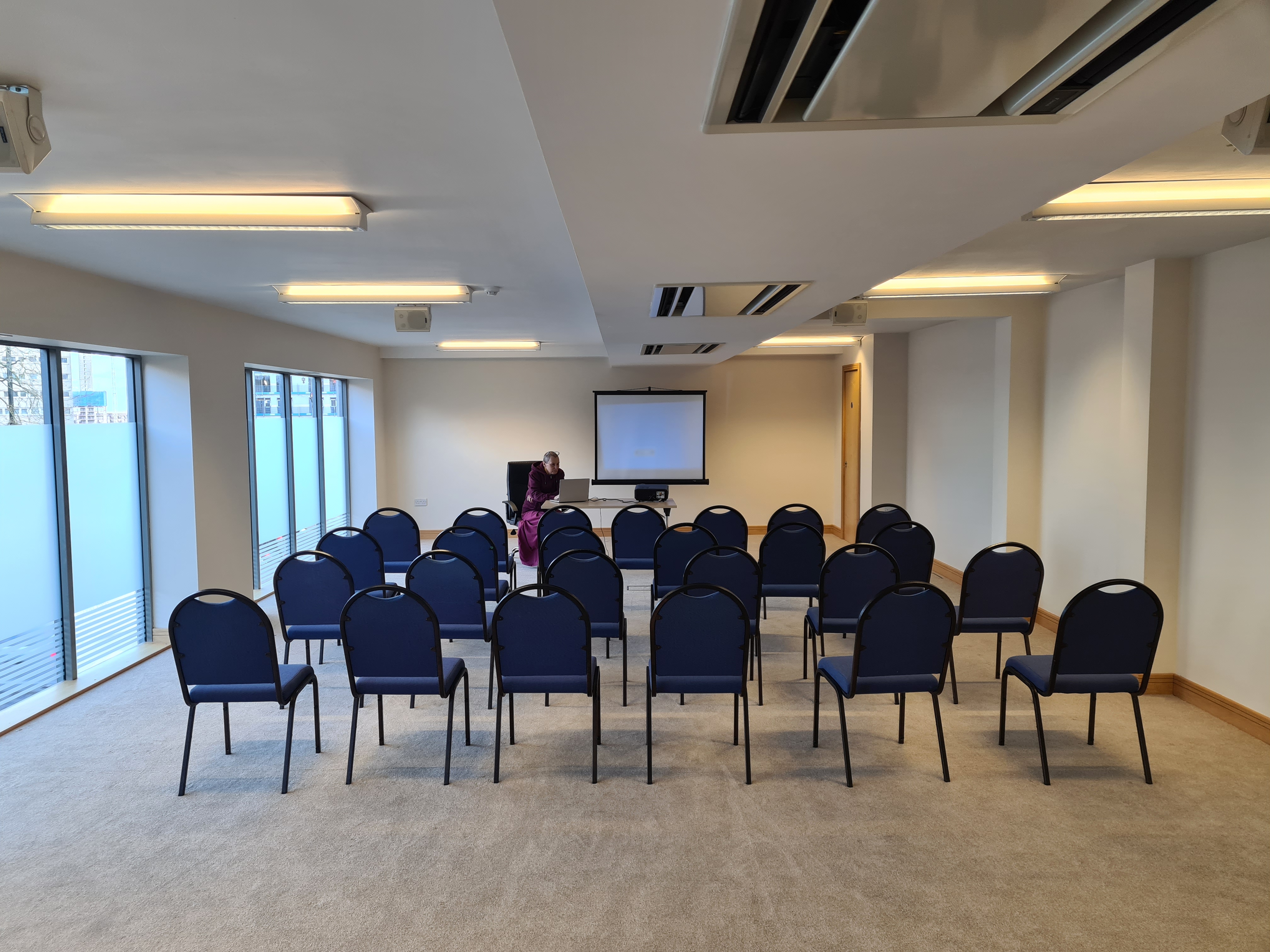 Upper Floor Suite meeting room with blue chairs, ideal for workshops and conferences.