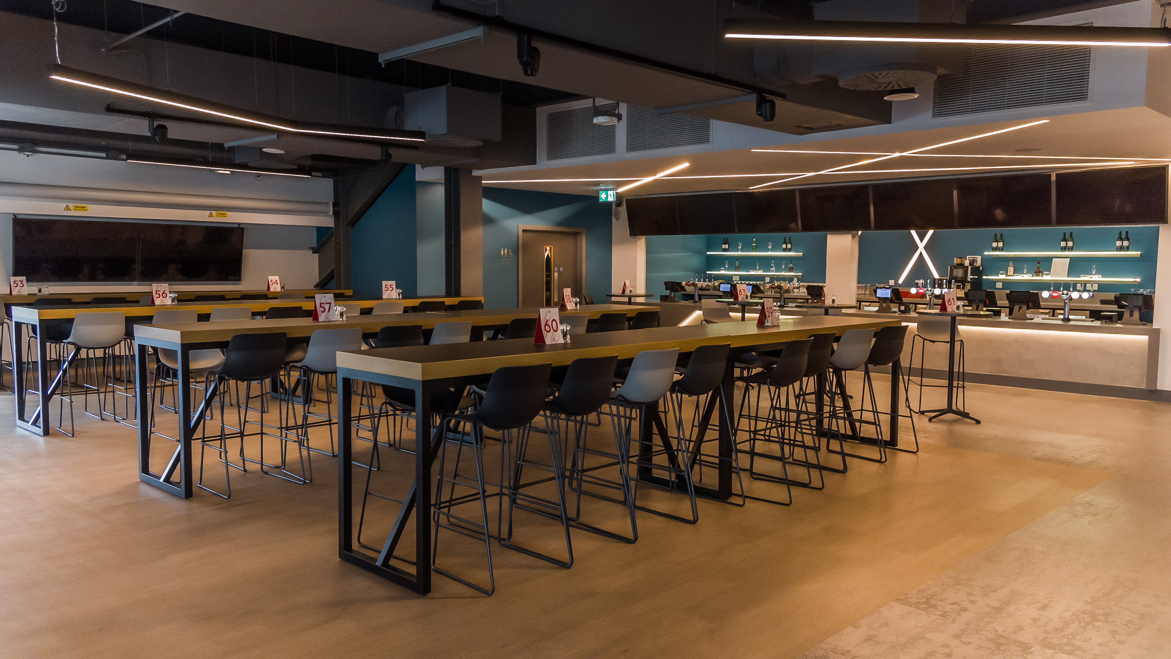 Legends Suite at Brentford FC: modern event space with communal tables for networking.