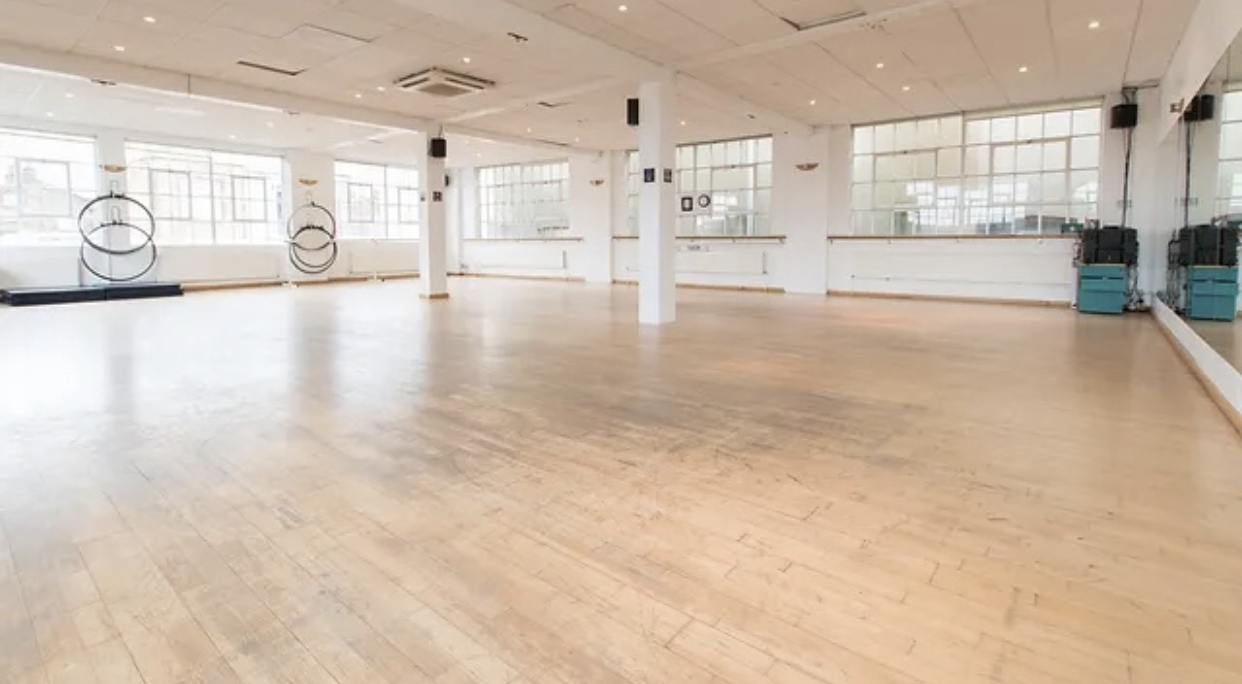 Spacious event space with wooden floors, ideal for fitness classes and workshops.