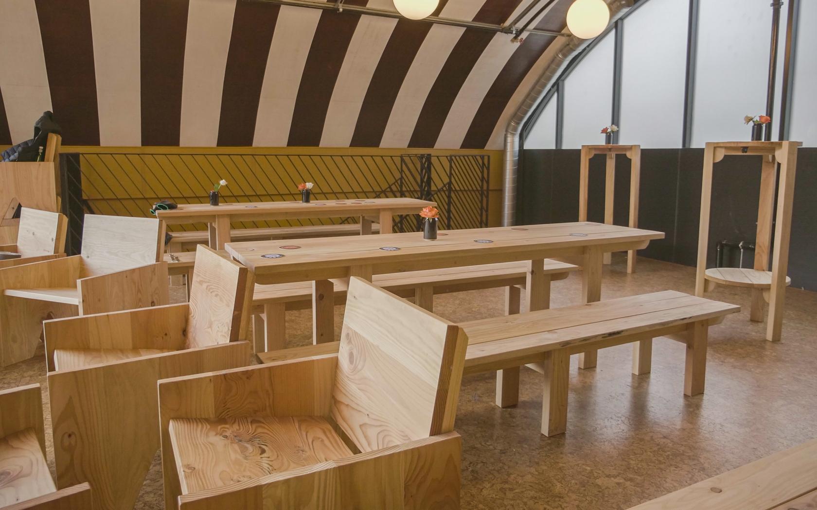 Versatile event space with wooden furniture, ideal for workshops and meetings.