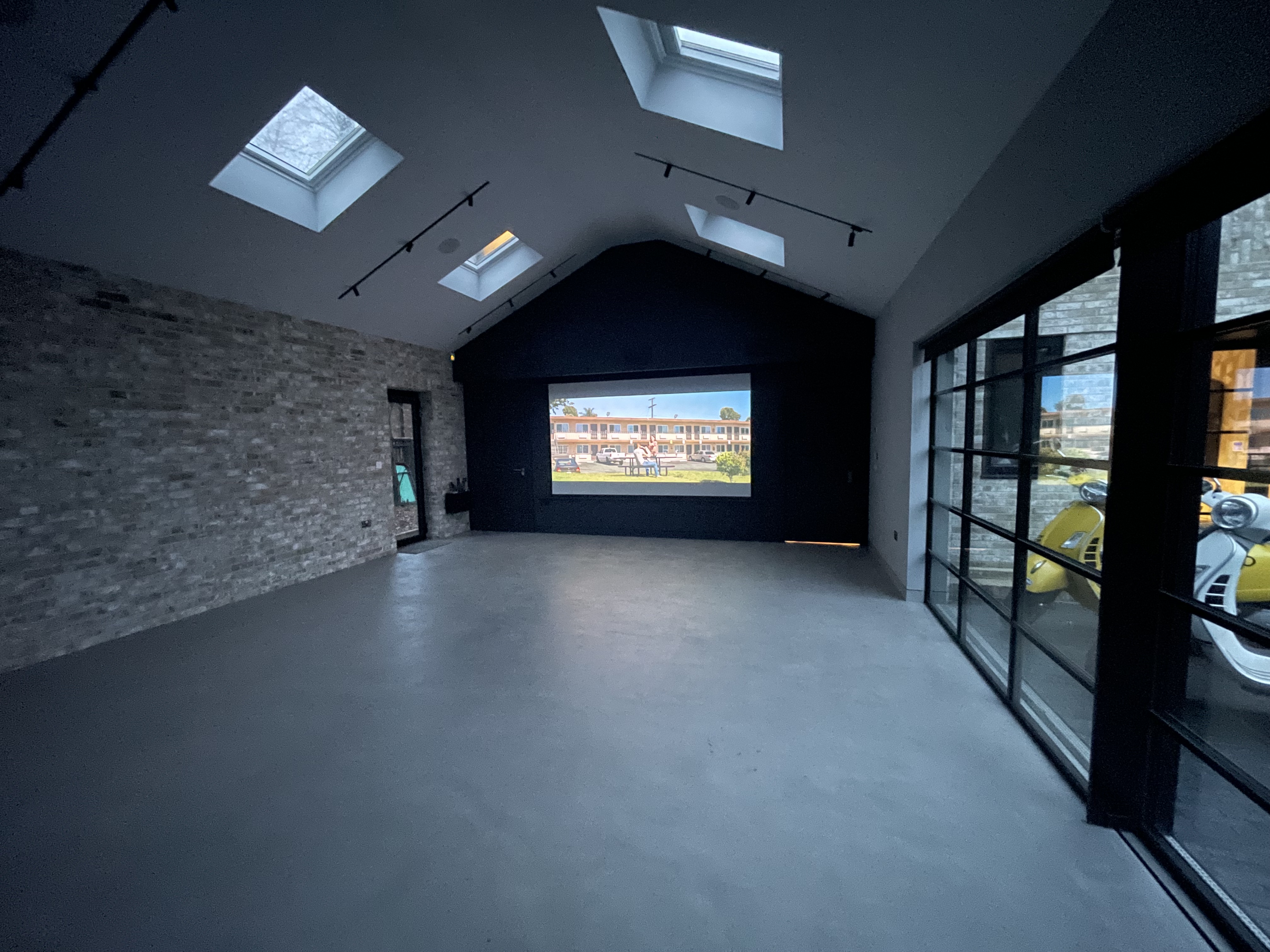 Versatile event space with large projection screen, ideal for presentations and screenings.