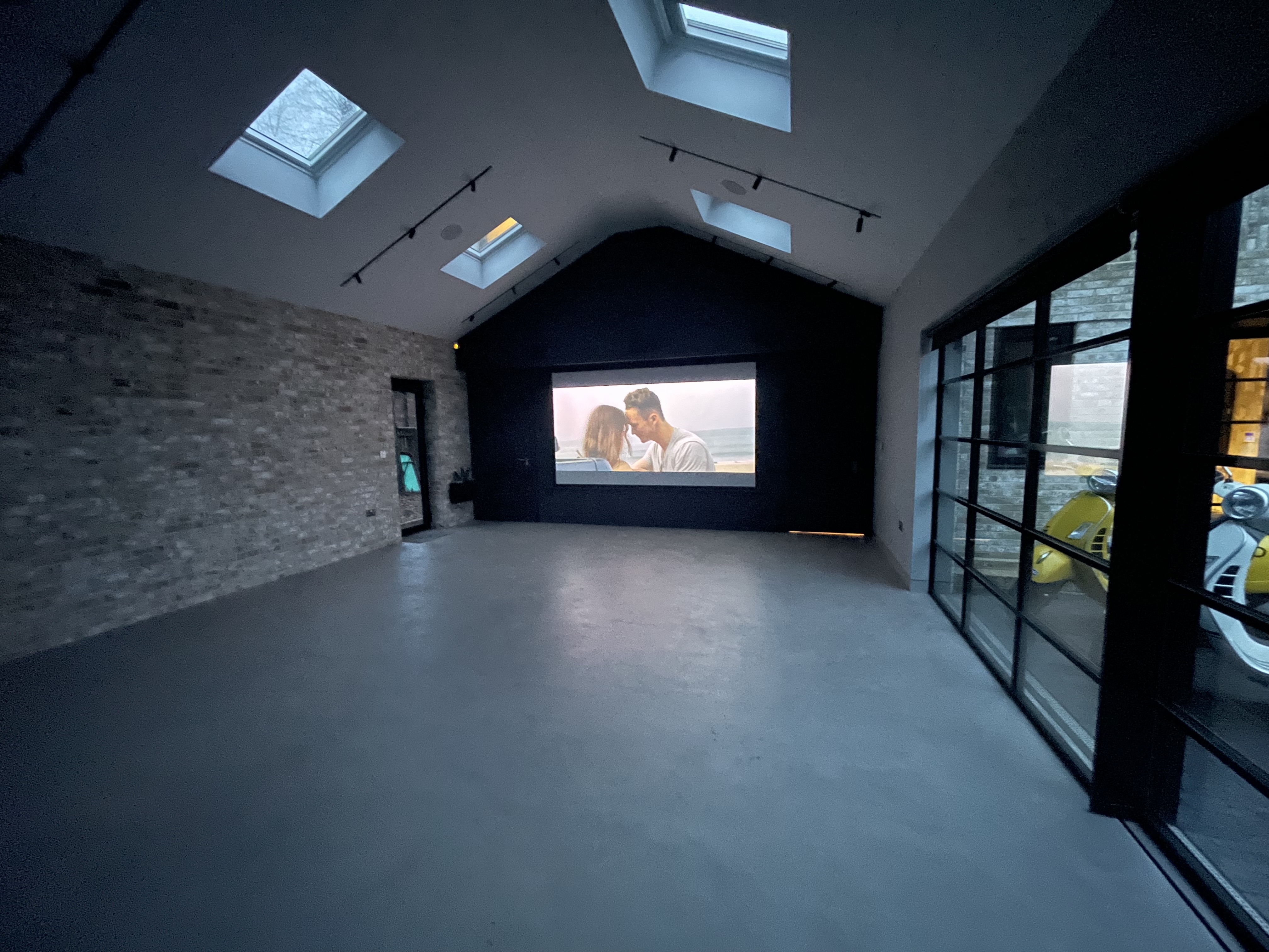 Versatile event space with large projection screen, ideal for presentations and workshops.