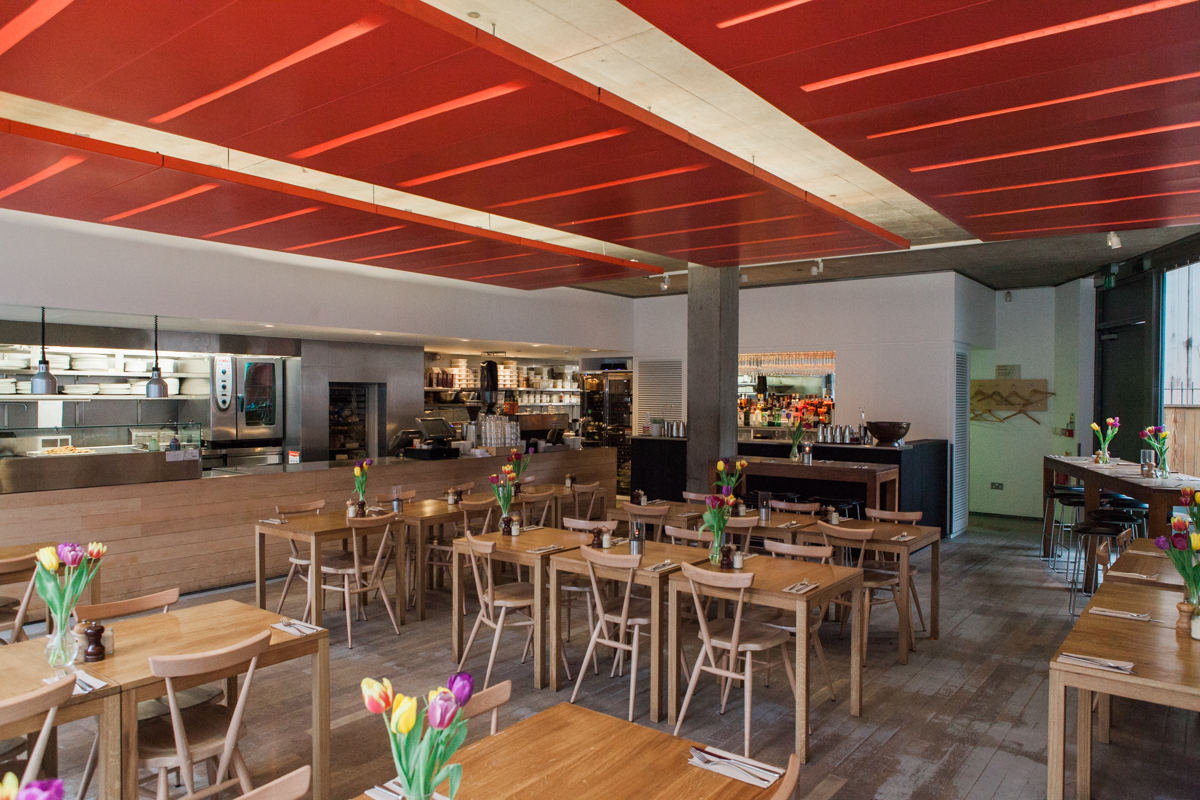 Modern restaurant interior with warm wood tones, ideal for events and meetings.