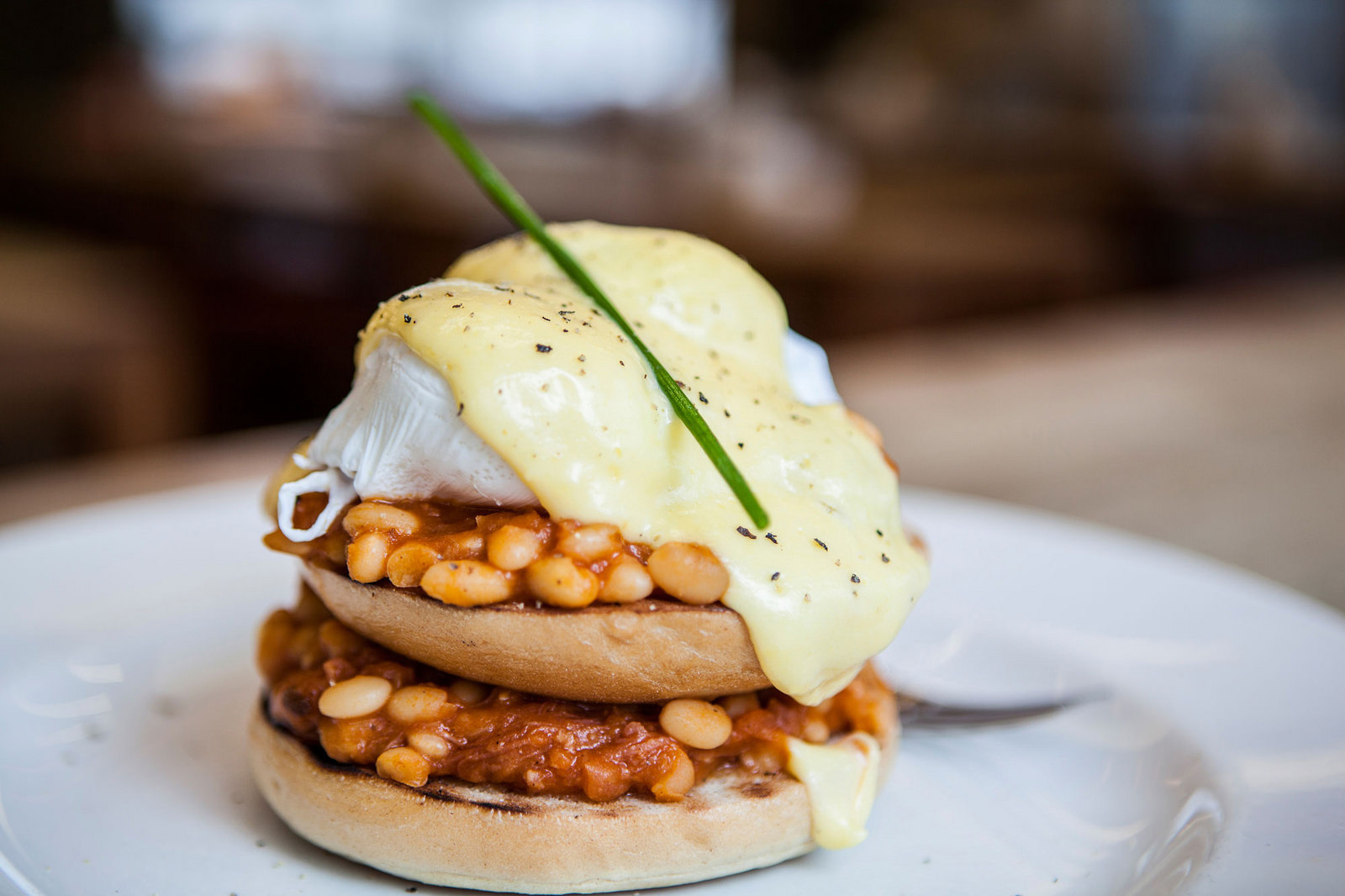 Upscale brunch dish with poached eggs, baked beans, and hollandaise at The Table Cafe.