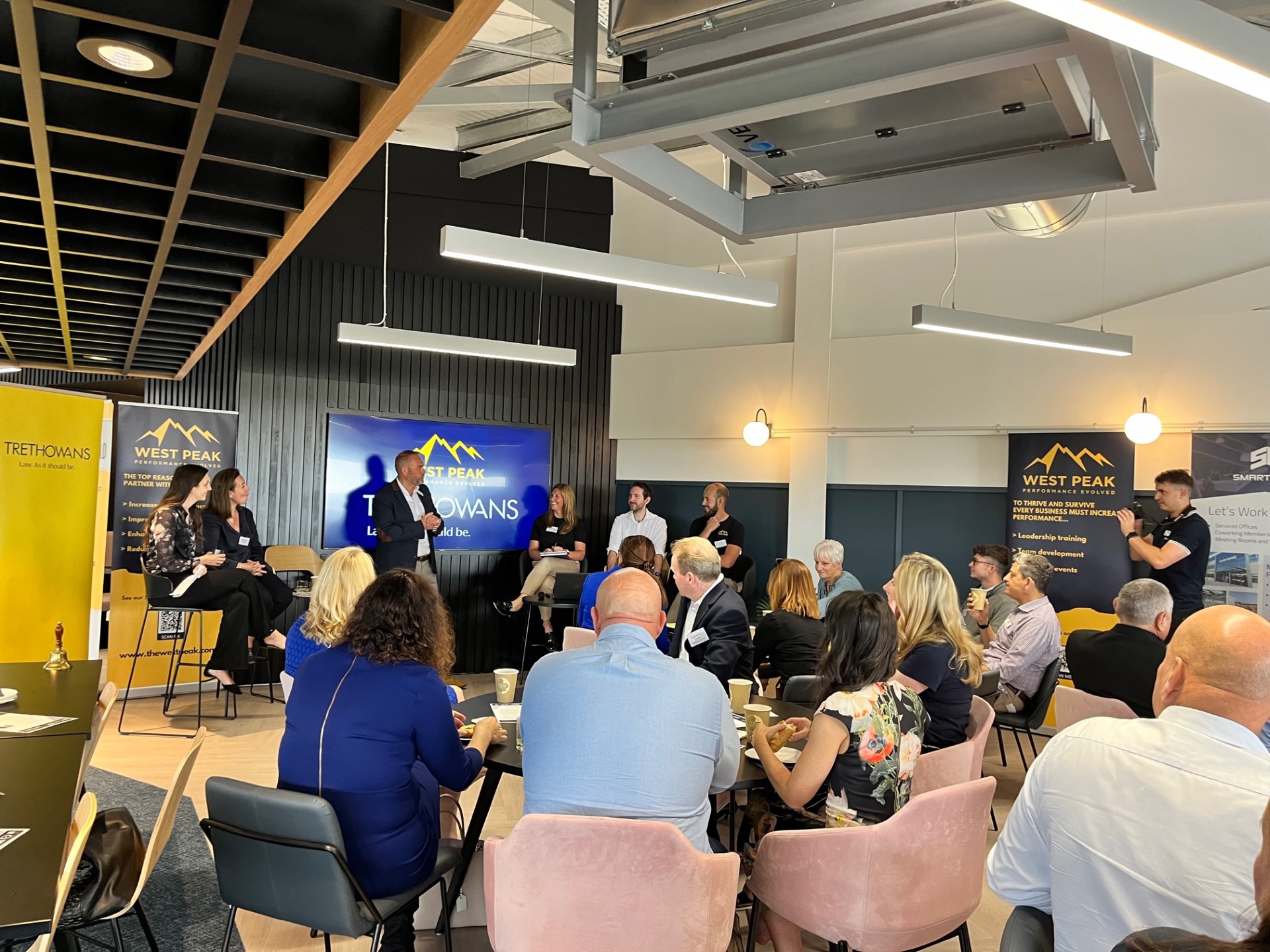 Networking event at SmartBase with engaged attendees and panel discussion setup.