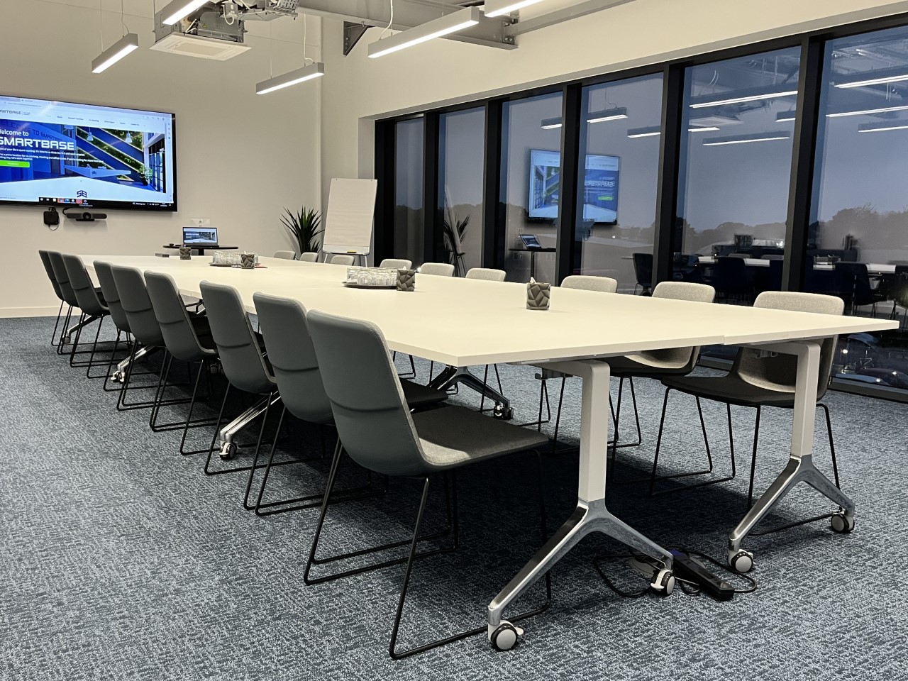 Modern conference room with sleek table, ideal for hybrid meetings and presentations.