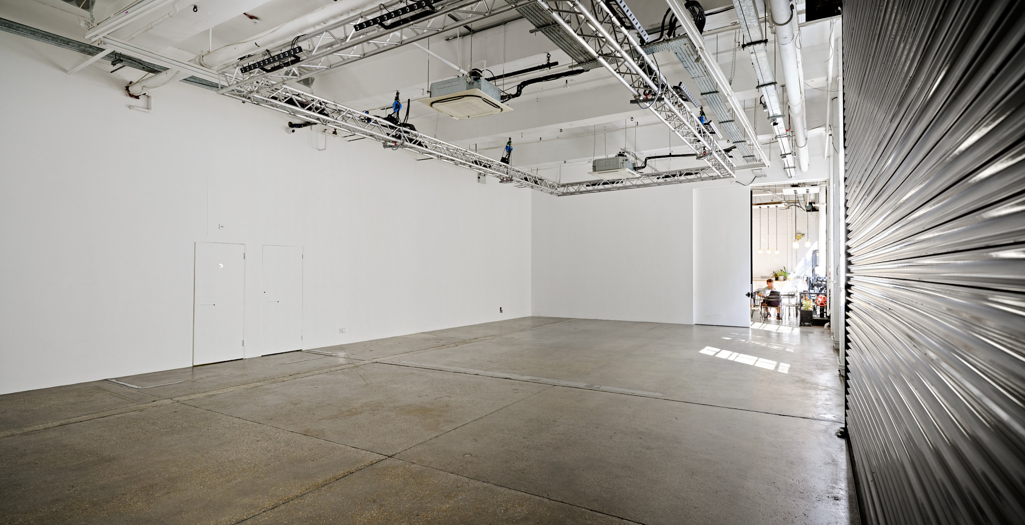 Versatile event space with high ceilings and natural light for workshops and exhibitions.