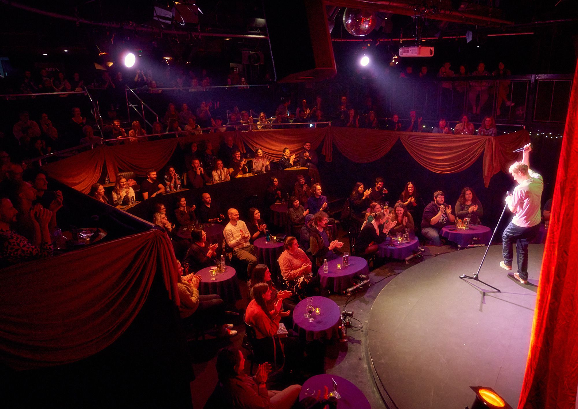Vibrant Pleasance Theatre performance space with circular stage, ideal for comedy shows.