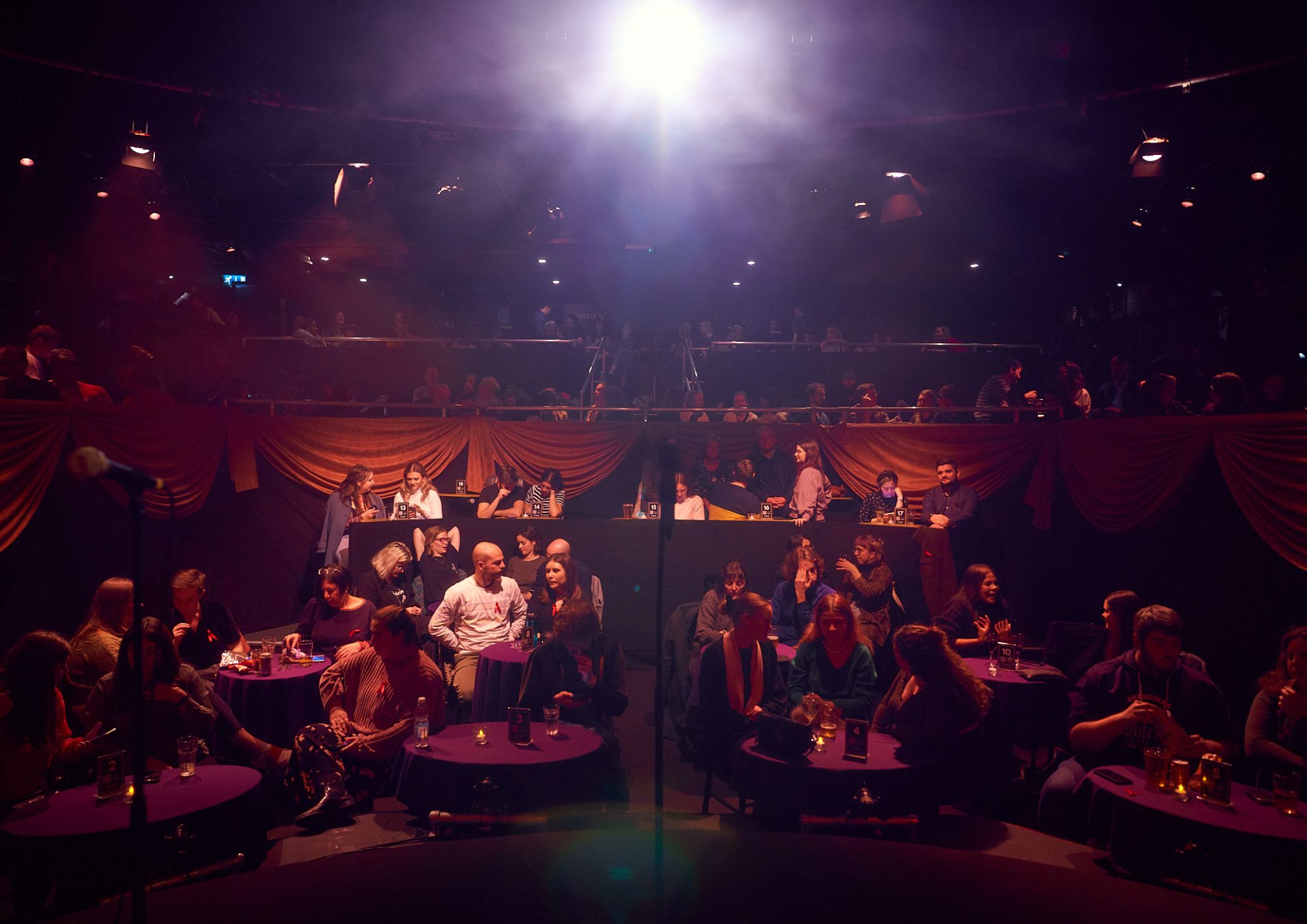 "Pleasance Theatre event space with engaged audience and spotlighted stage for performances."