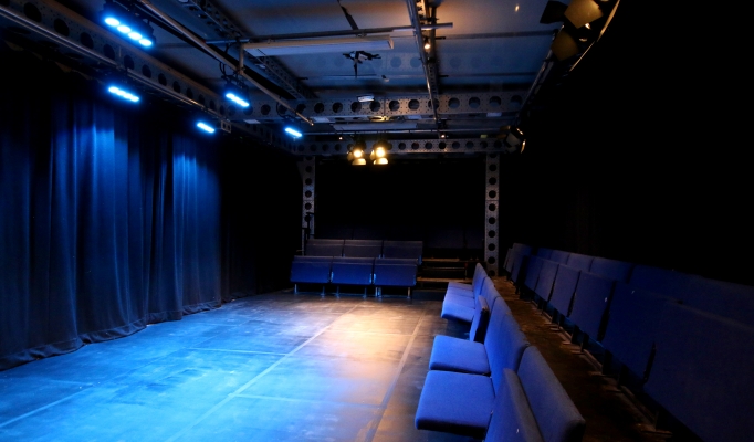 Intimate performance space at Pleasance Theatre with blue lighting for workshops and events.