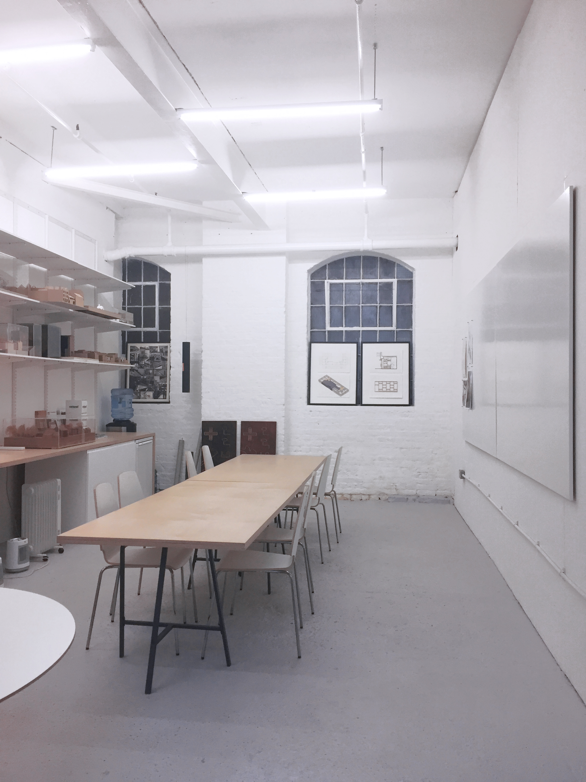 Minimalist meeting room with wooden table, ideal for workshops and brainstorming sessions.