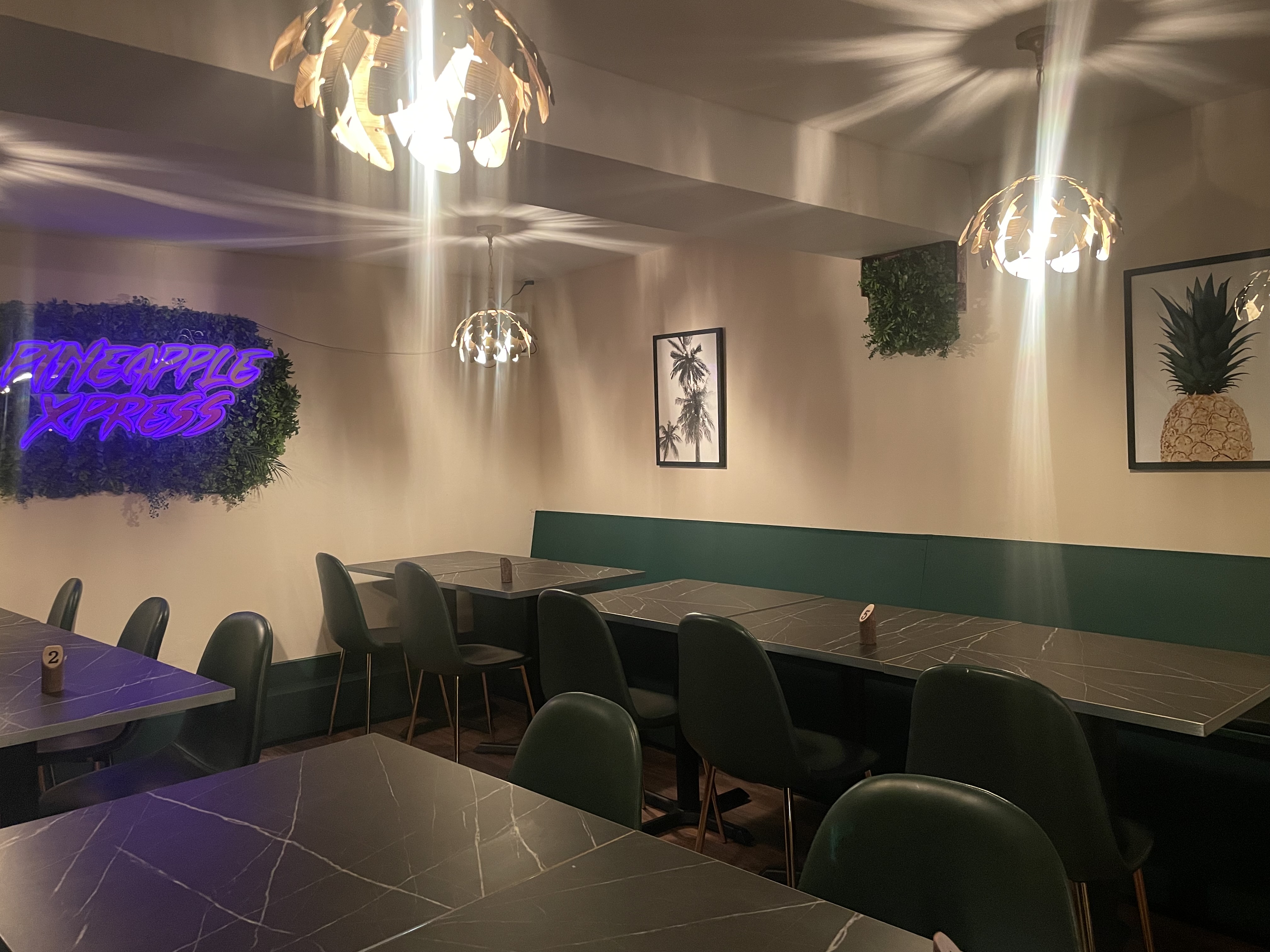 Stylish tropical event space with neon sign, perfect for gatherings and social functions.
