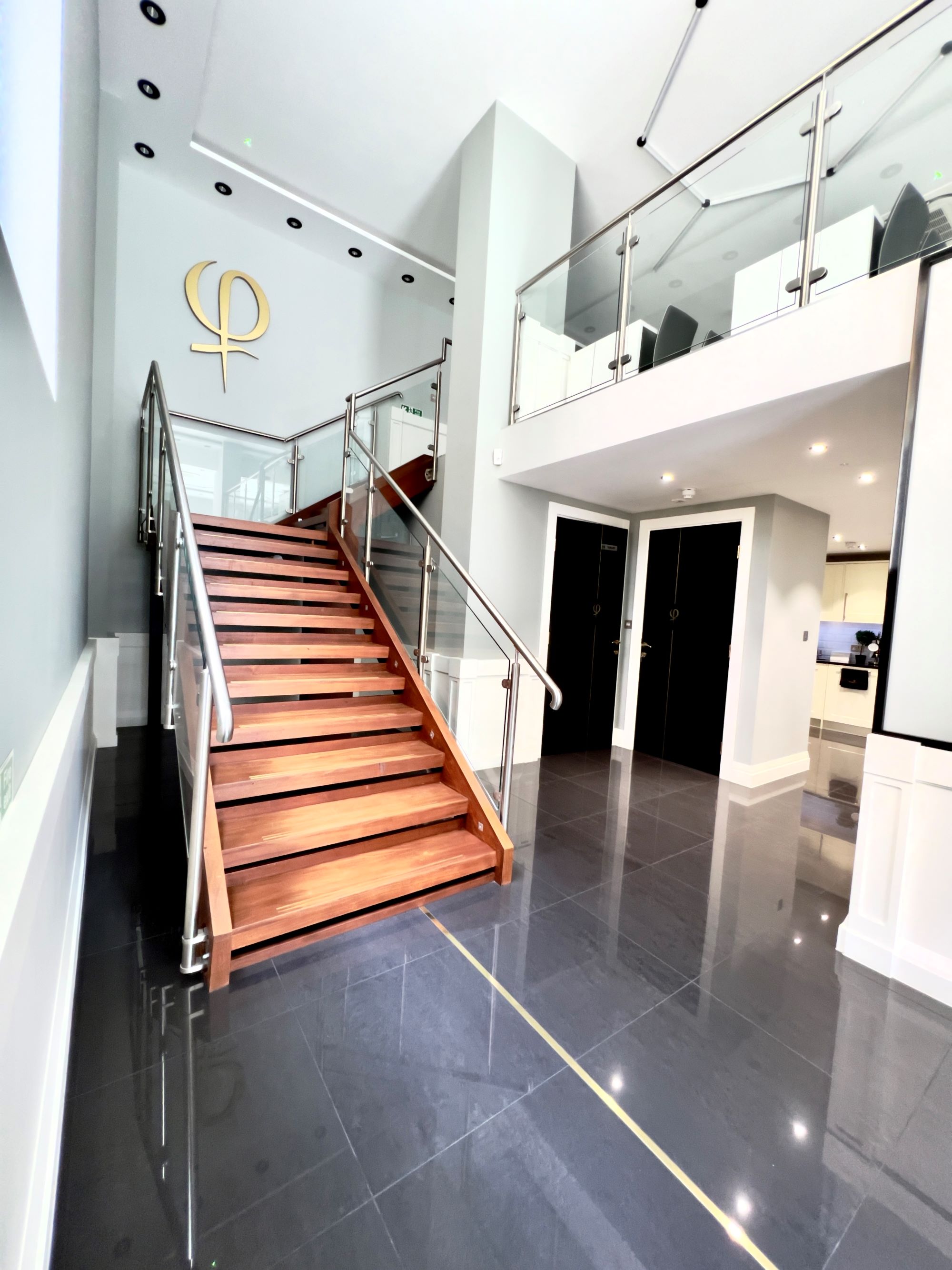 Modern entryway of Phi Academy with wooden staircase, ideal for events and meetings.
