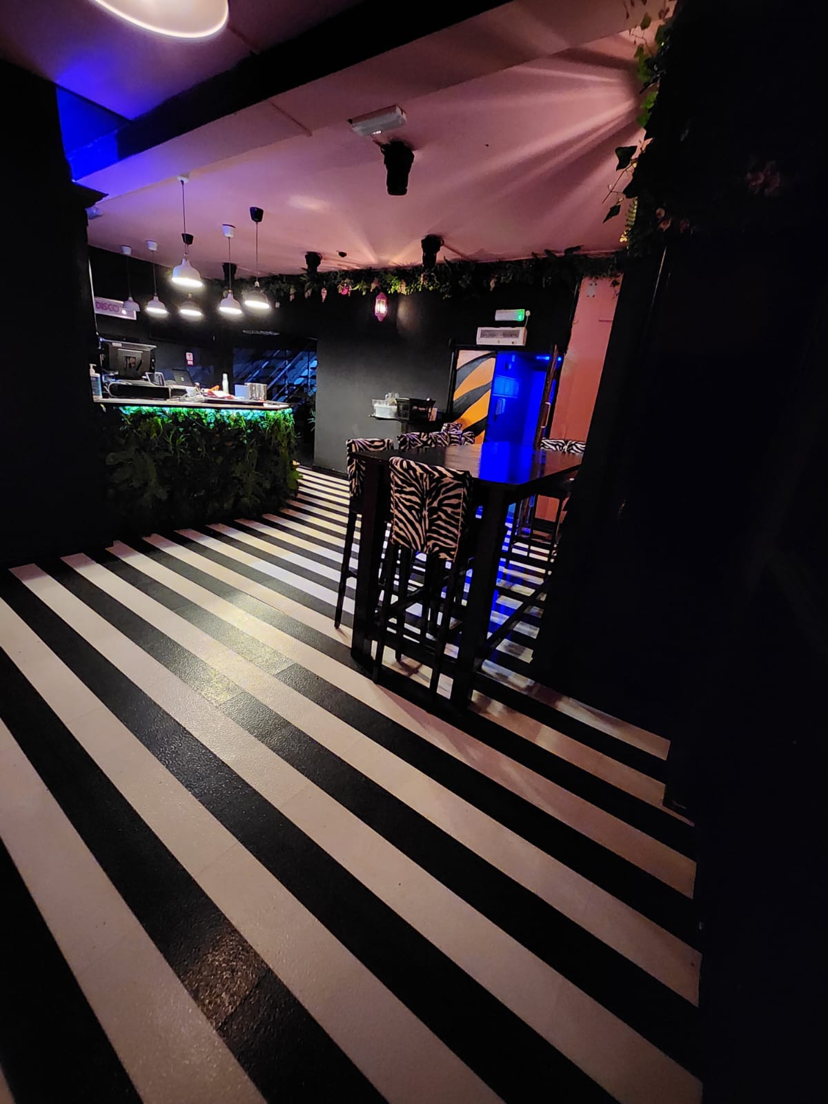 VIP area with balcony at BUNA Lounge, featuring a striking black and white striped floor.