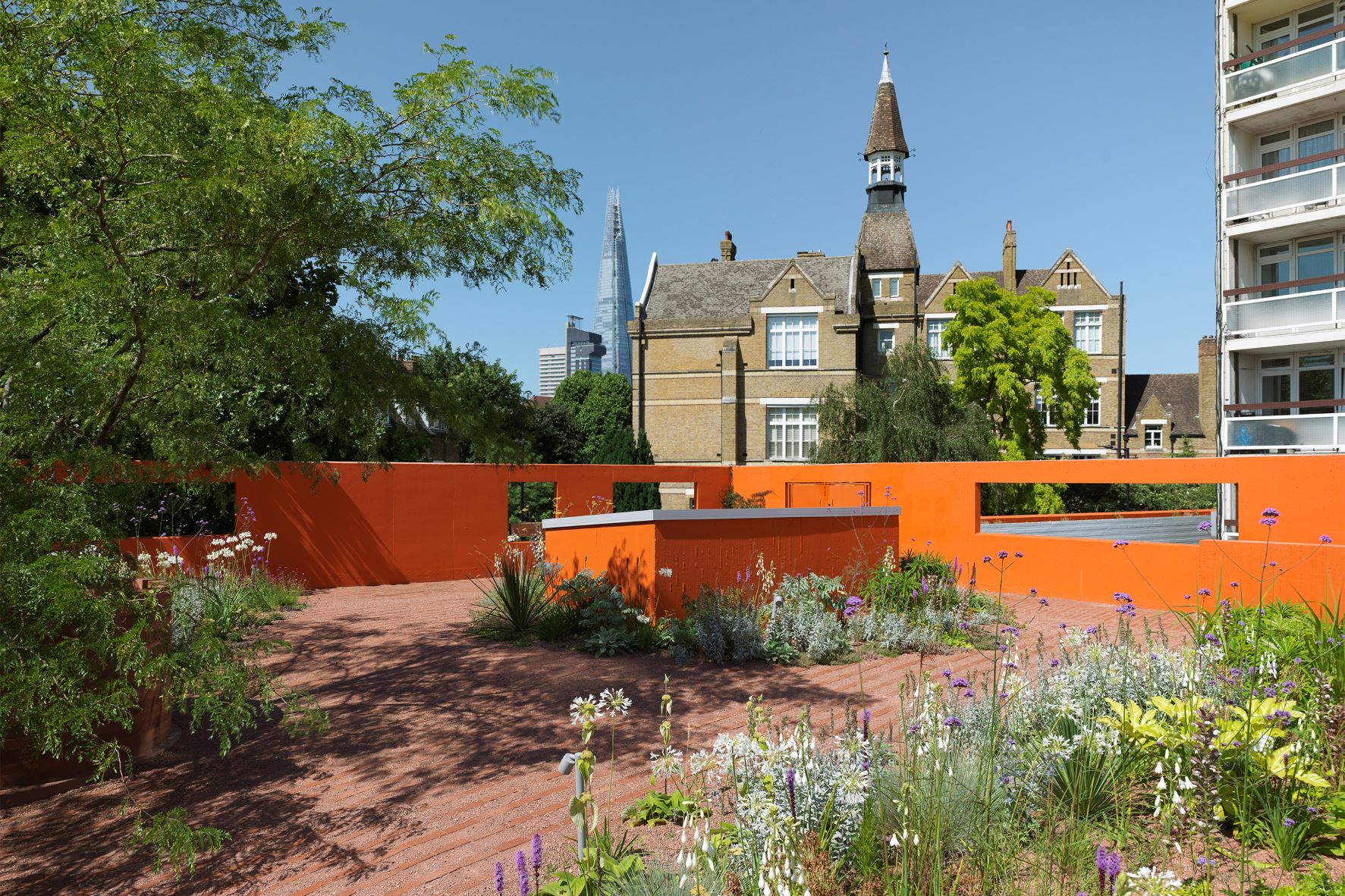Vibrant Forma HQ outdoor space with orange wall, perfect for events and gatherings.