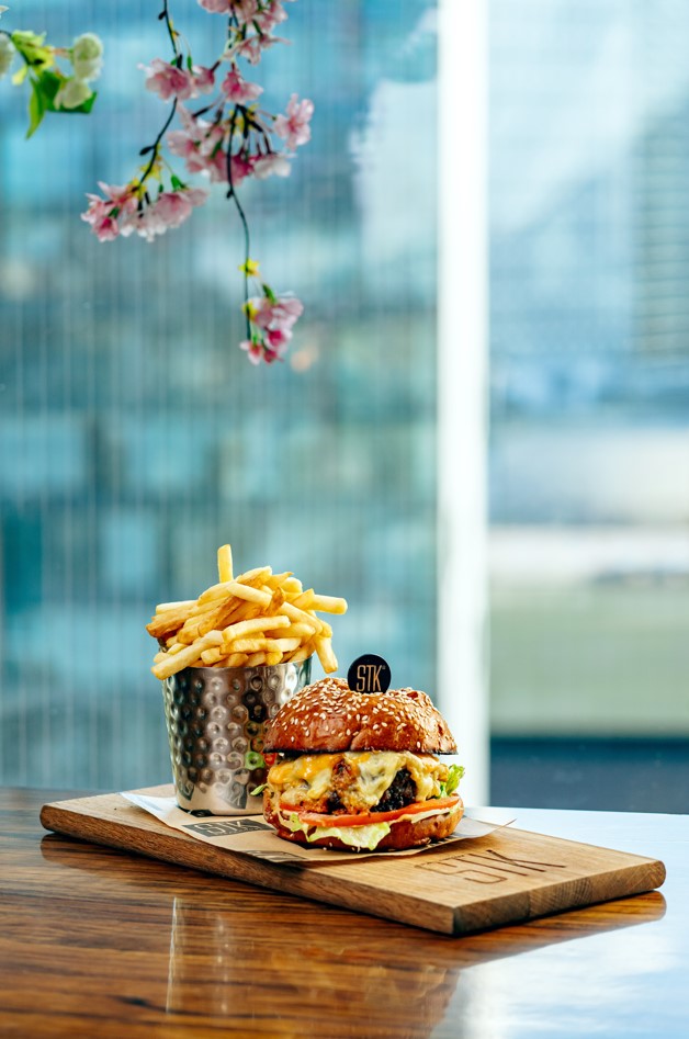 Gourmet burger with fries at STK Rooftop, perfect for upscale dining events.