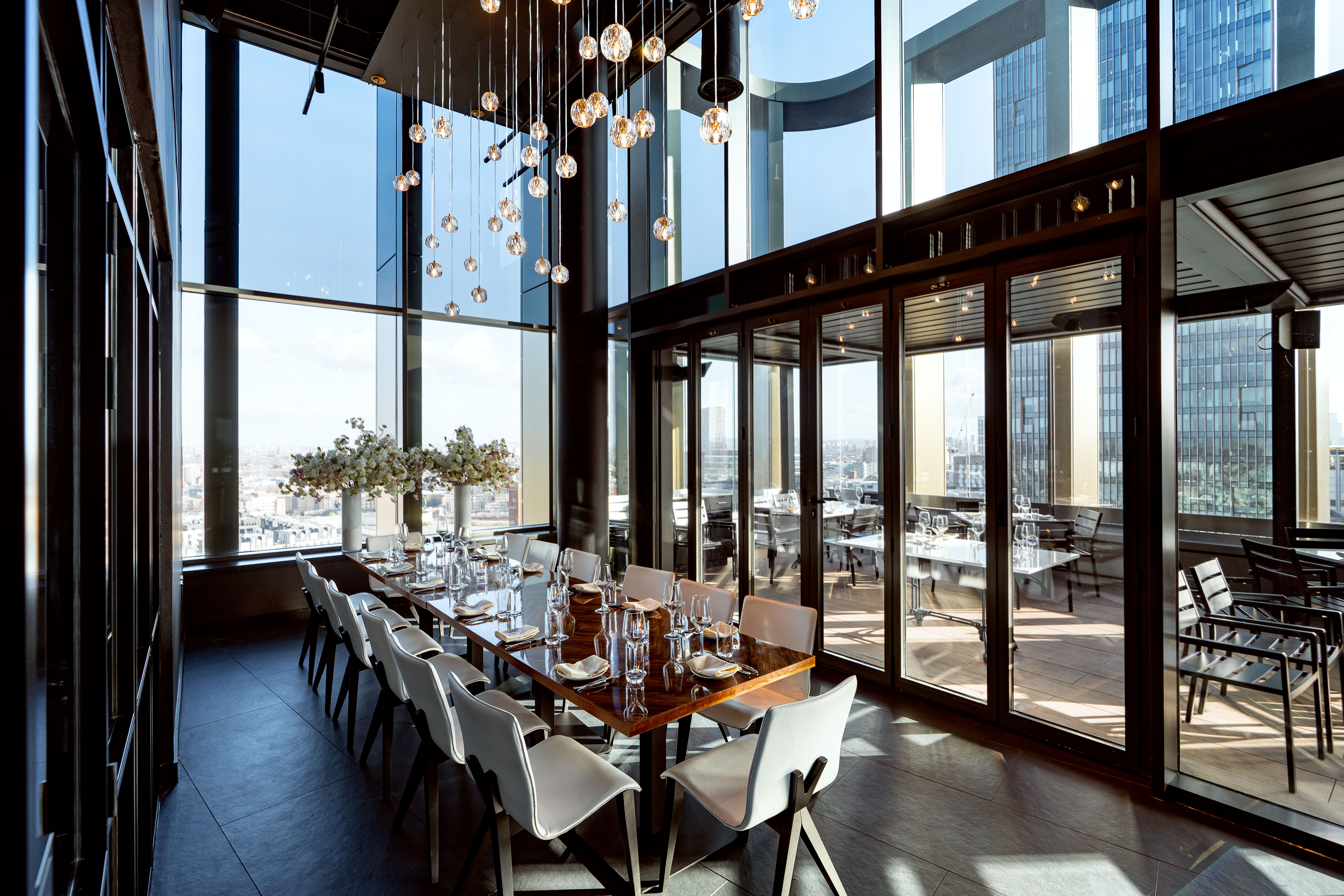 Private dining room with floor-to-ceiling windows at STK Rooftop Stratford for events.